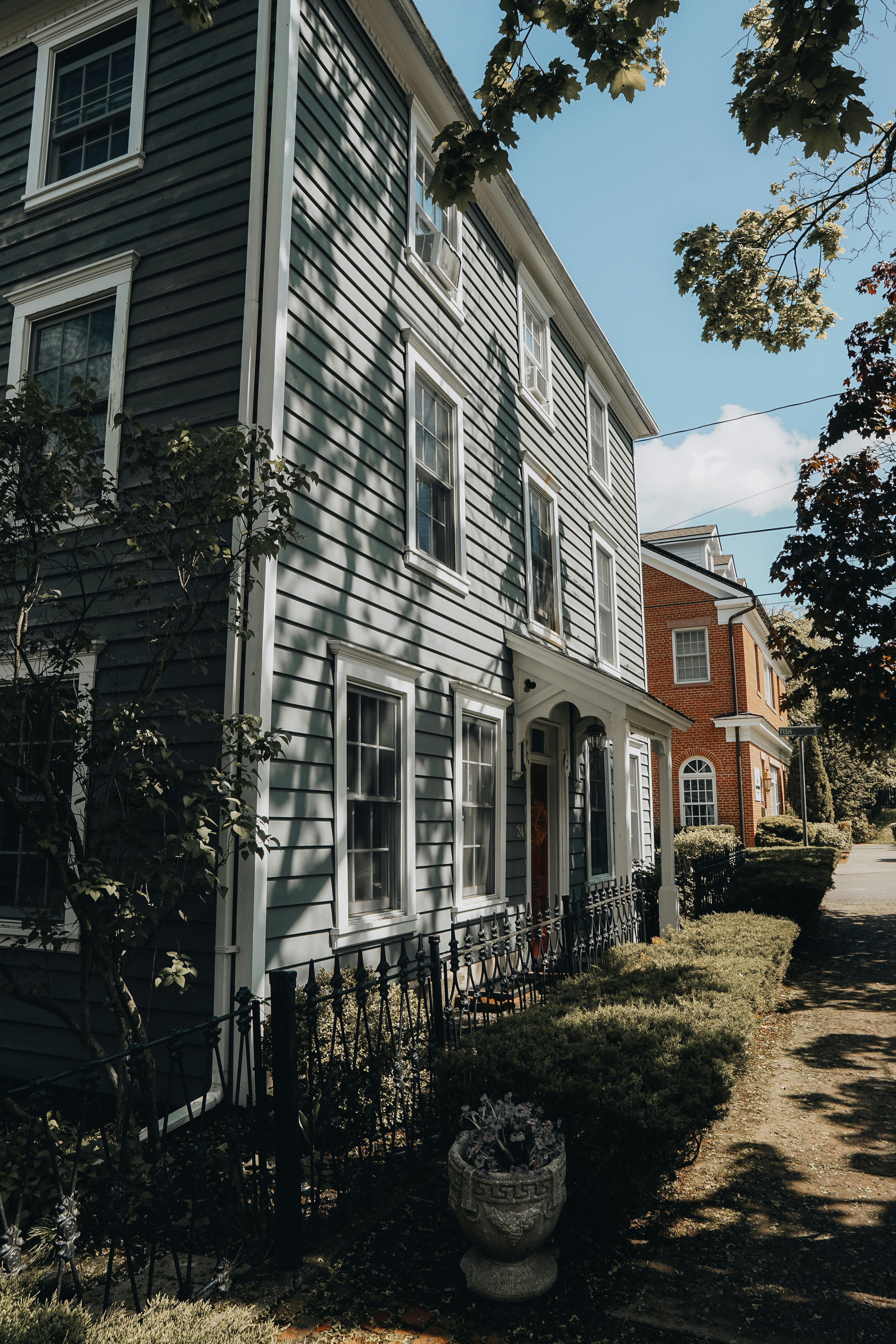 Historic houses line a quaint, sunny street.