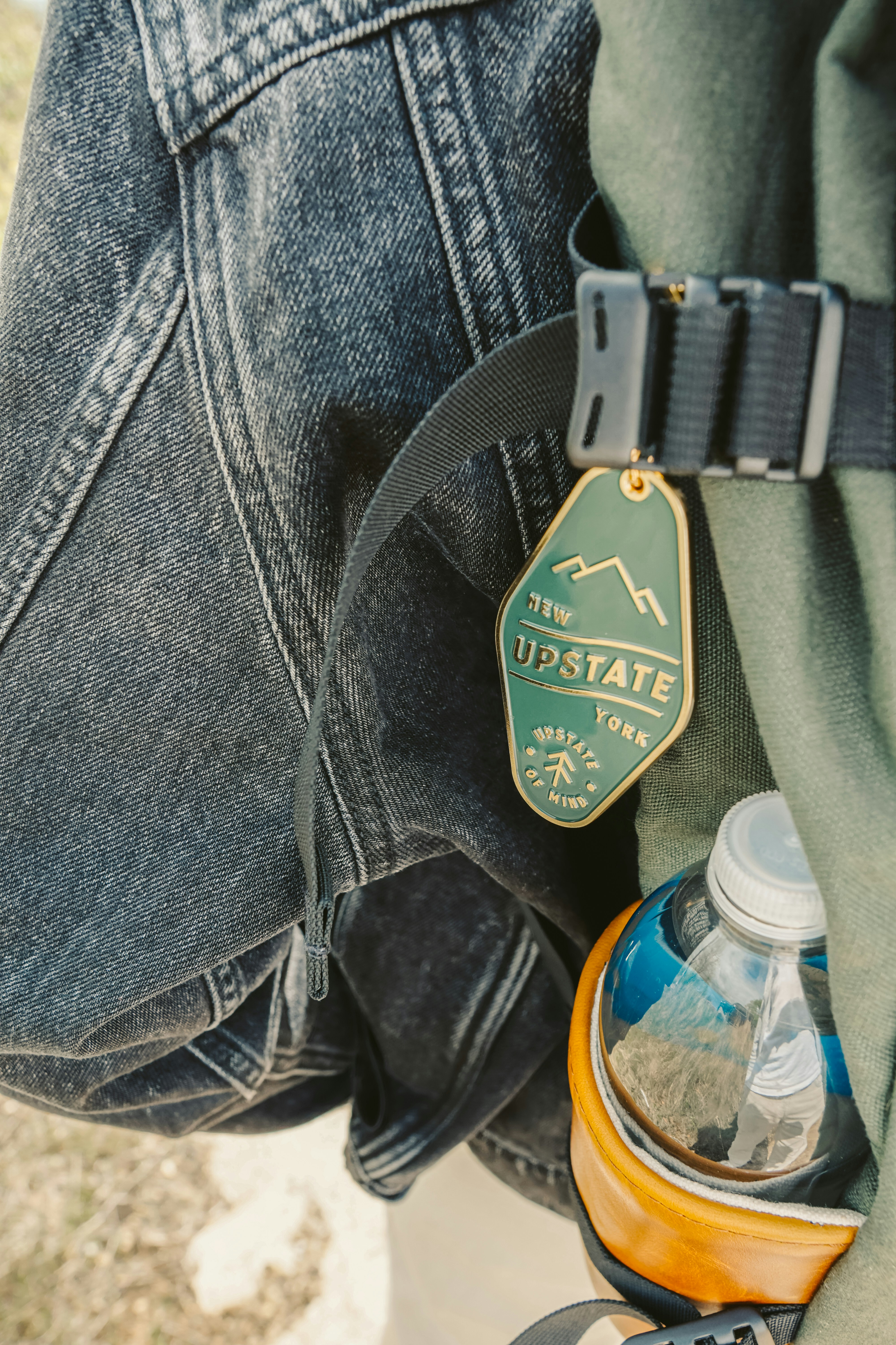 Backpack with tag, jacket, and water bottle.