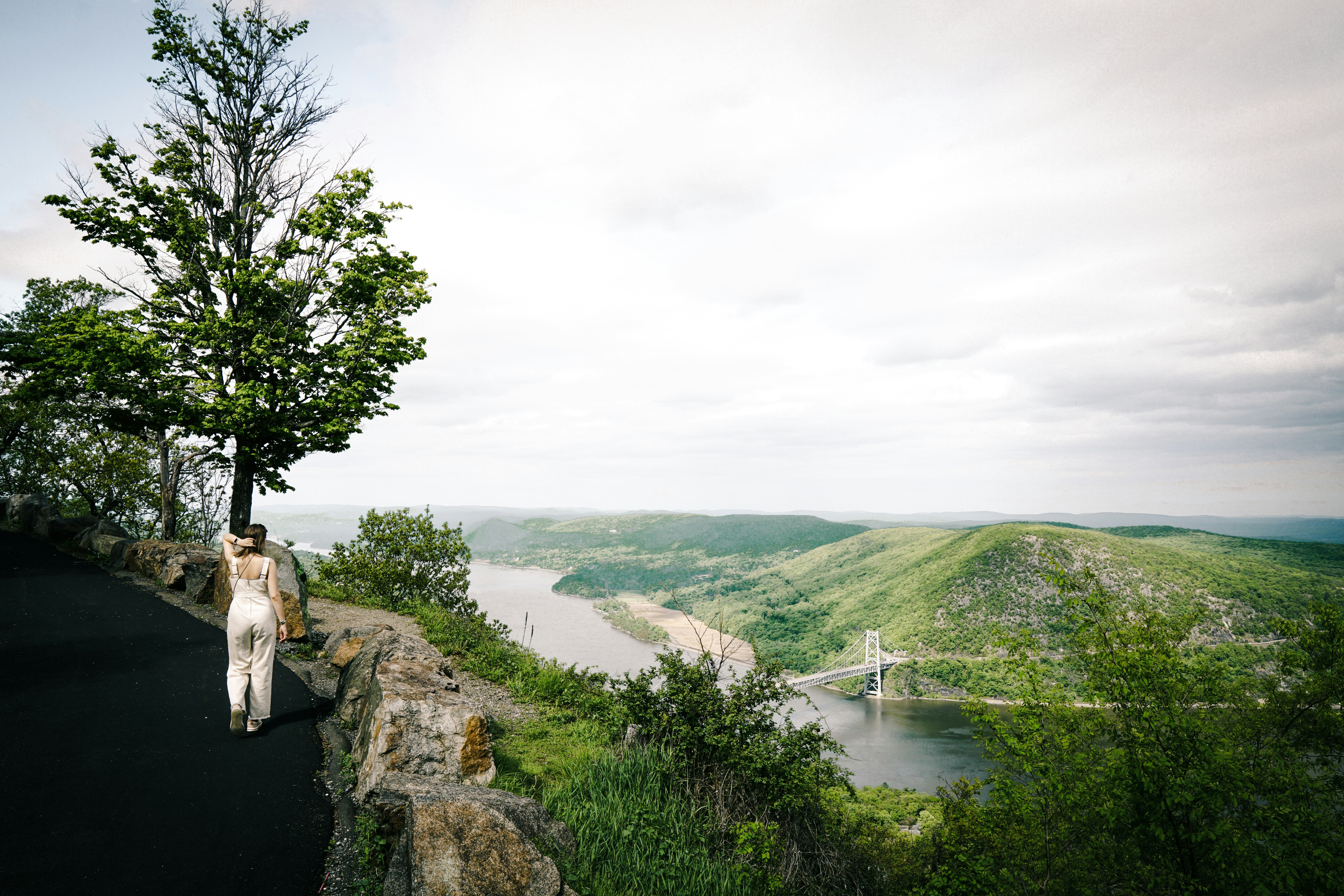 A bride poses beside a scenic river view