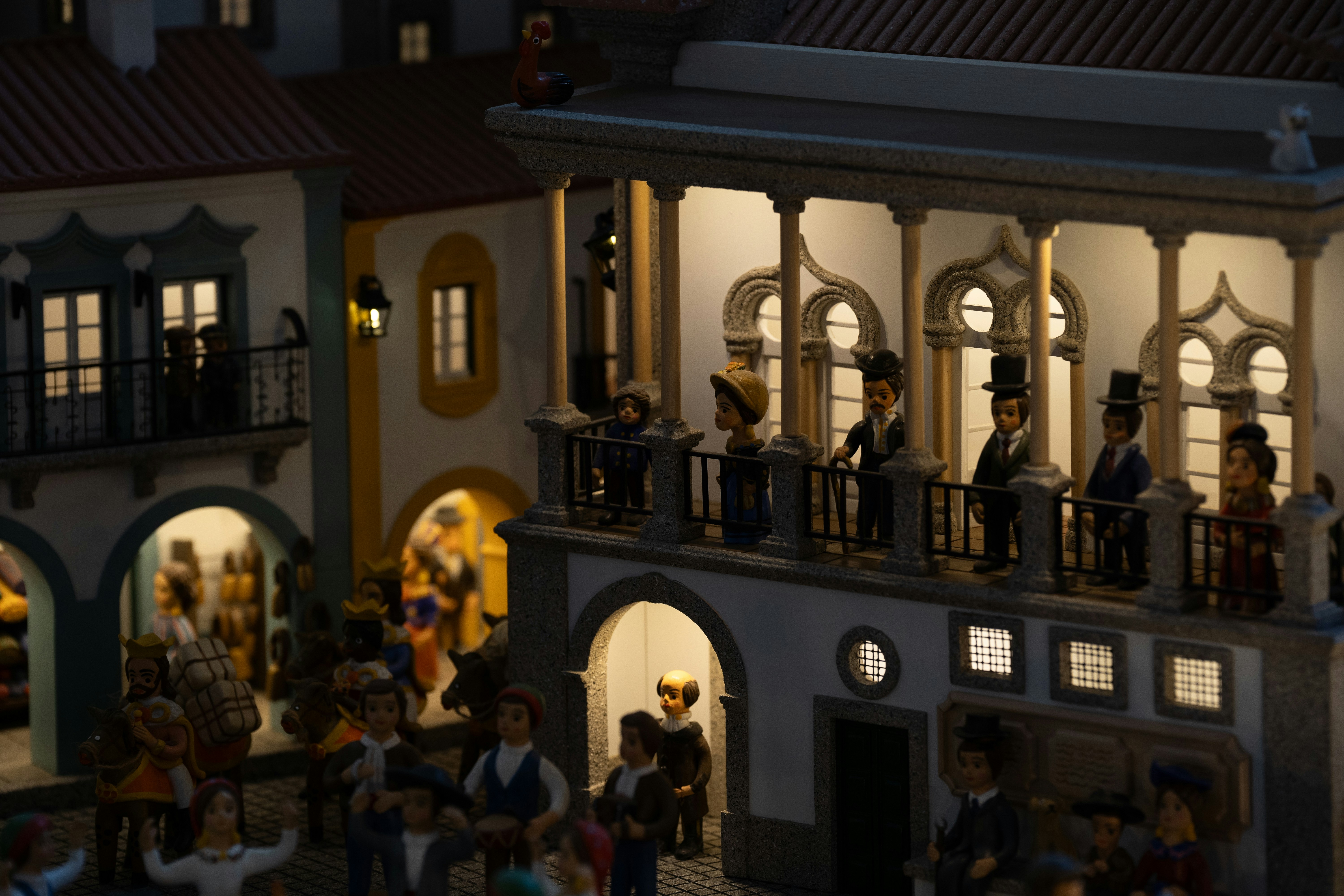 Des personnages miniatures se rassemblent sur les balcons des immeubles.