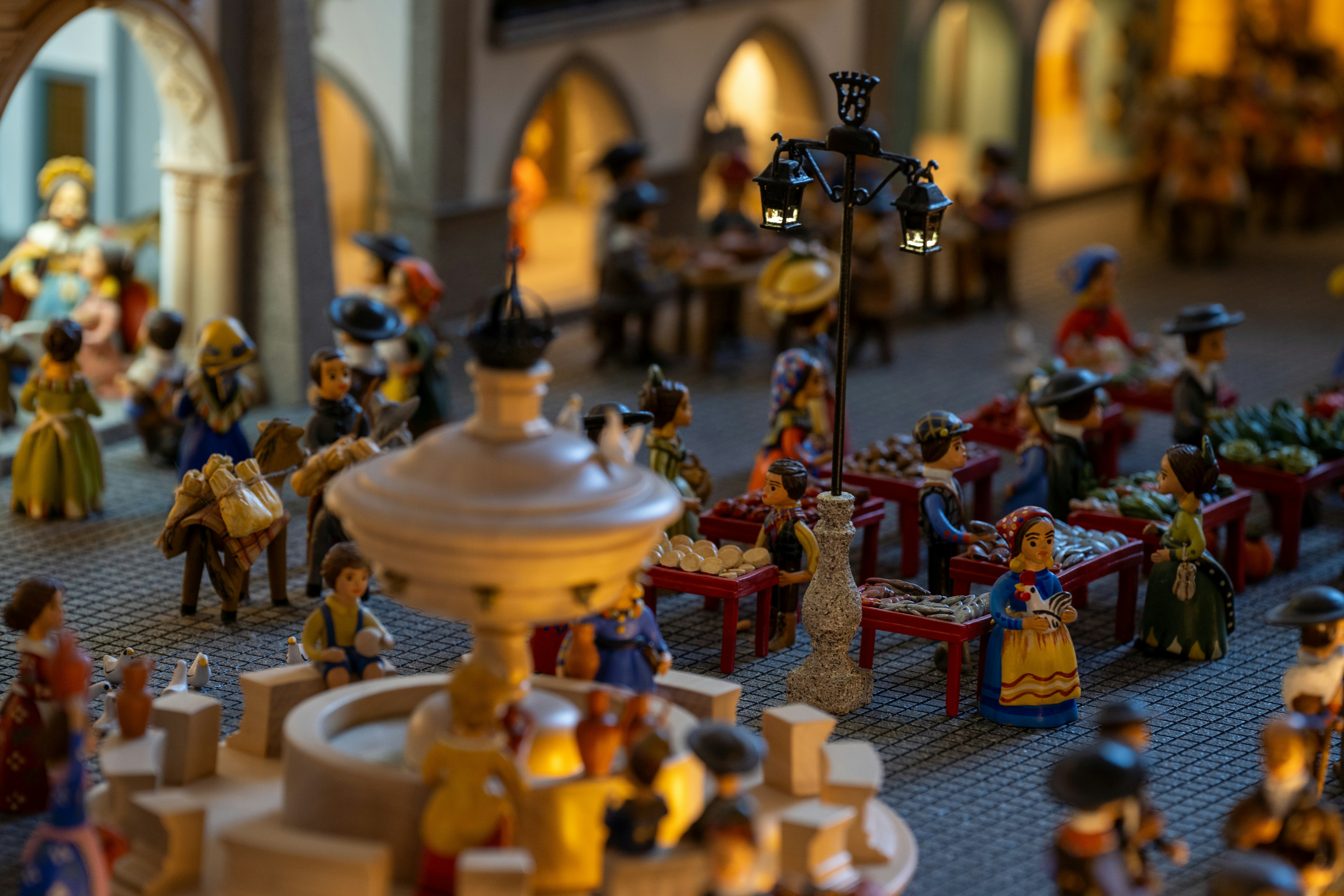 Des figurines miniatures représentent une place de ville animée.