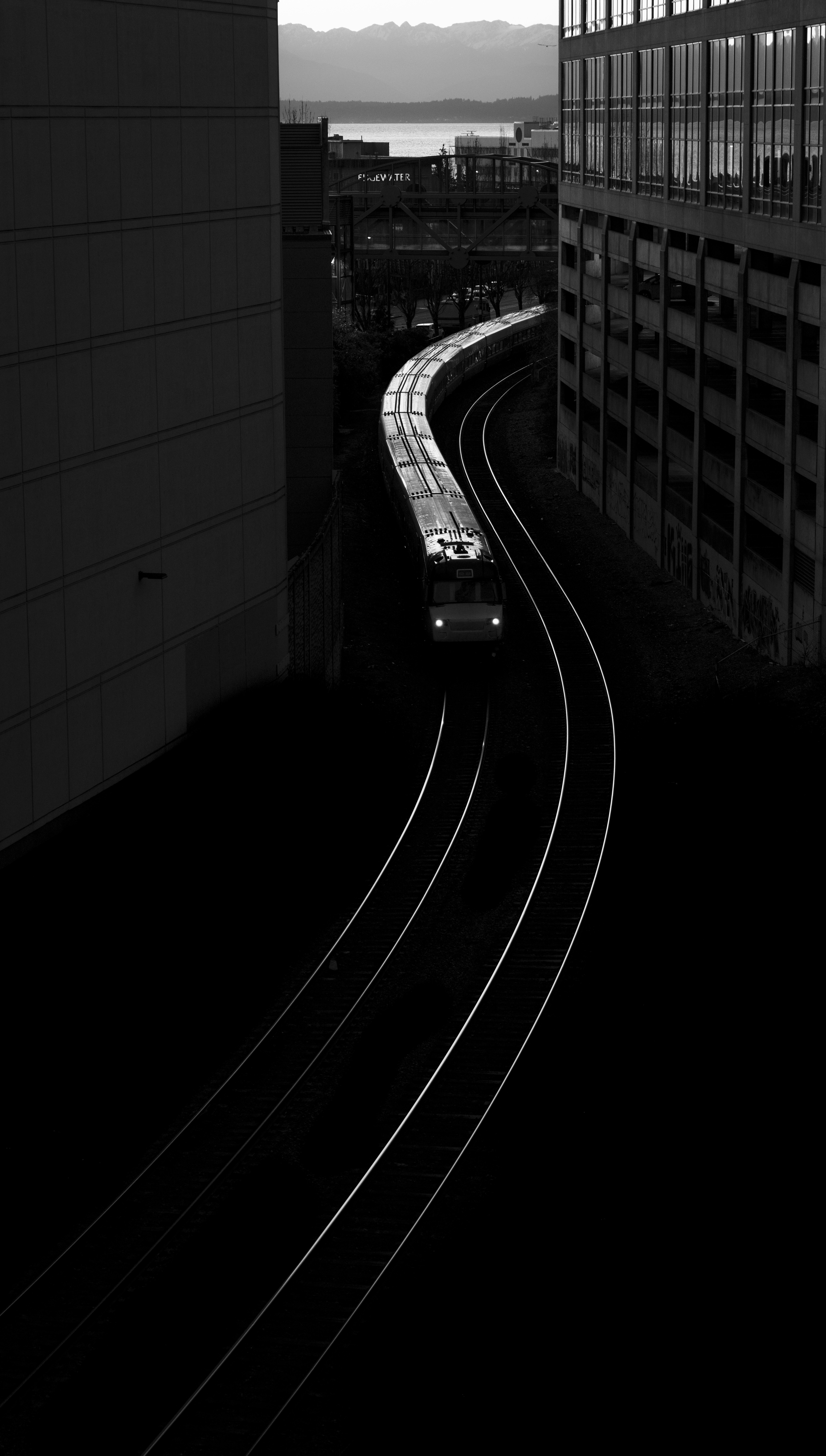 Train traveling through an urban landscape at dusk.