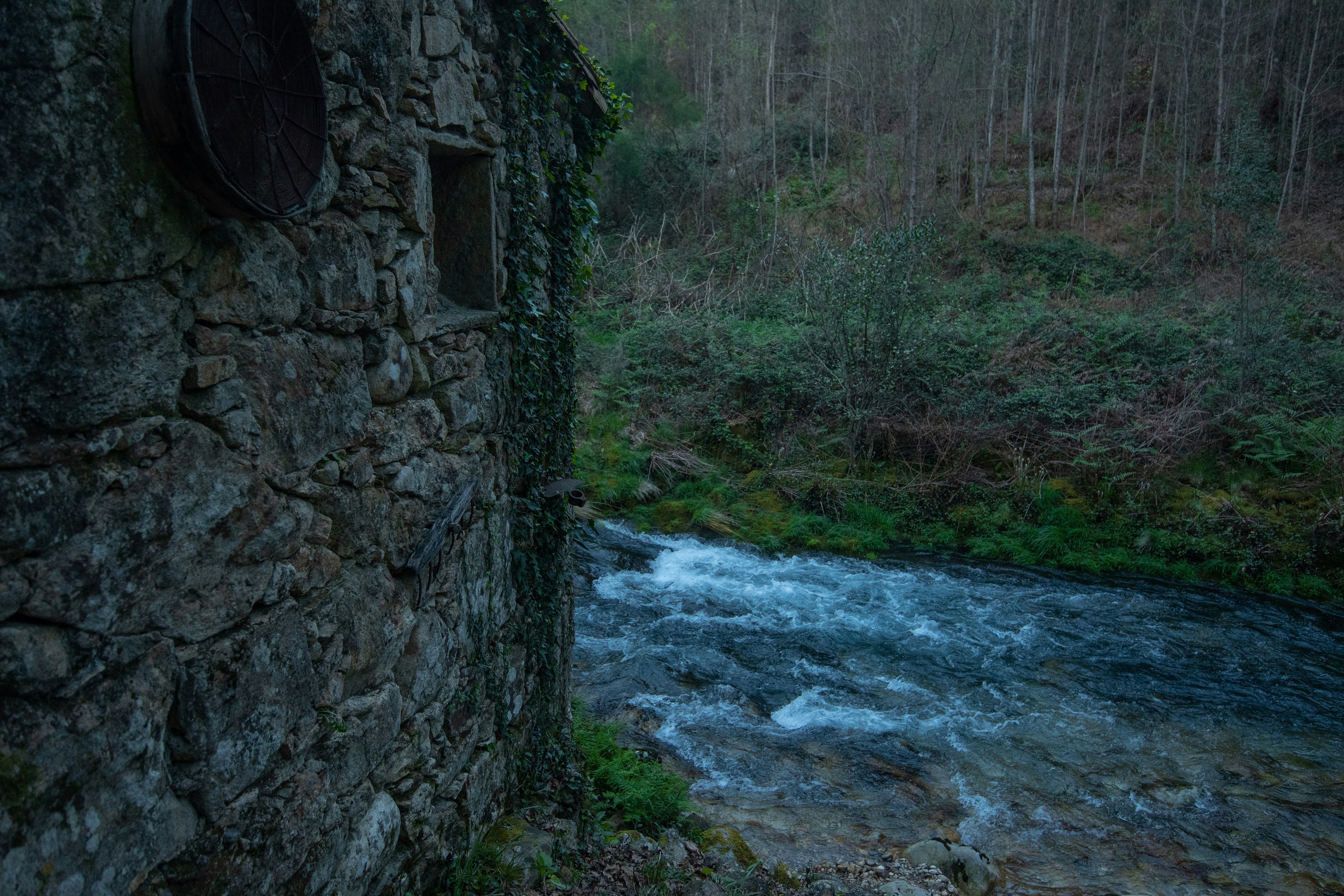 Old stone building beside a rushing river.