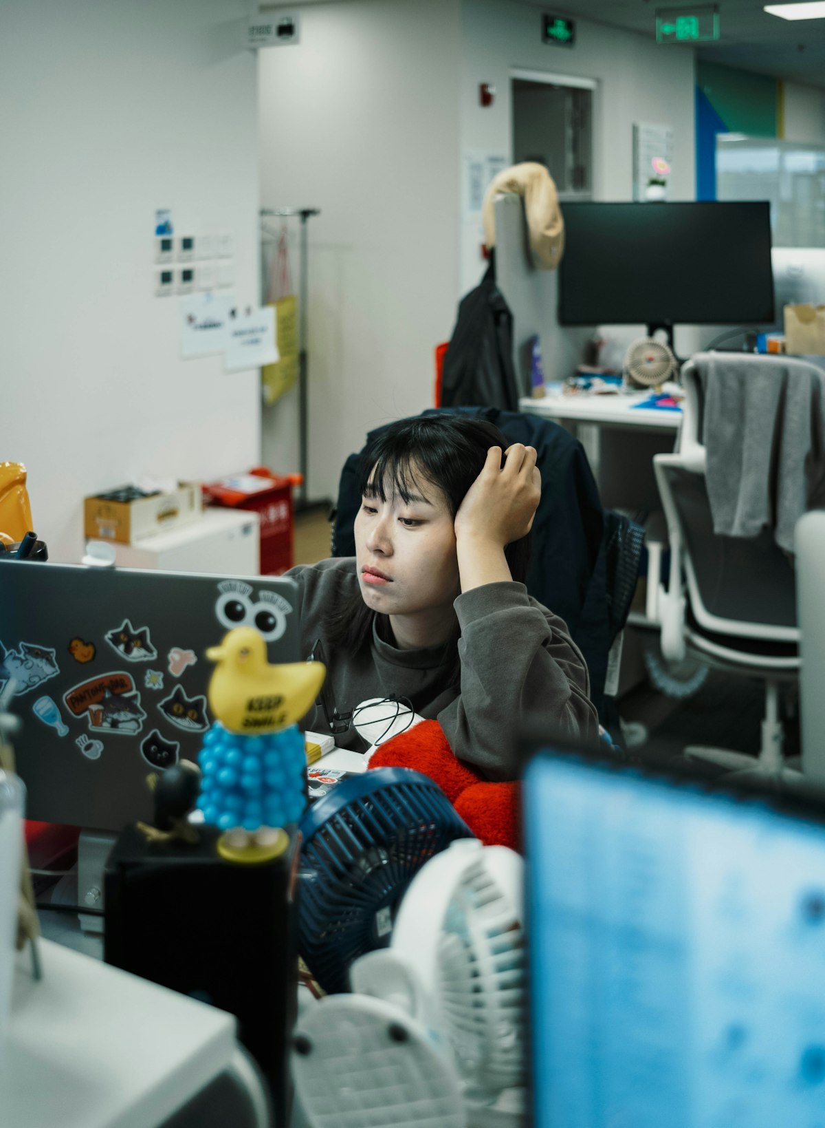 책상에 엎드려 졸린 표정으로 손에 머리를 기댄 직장인