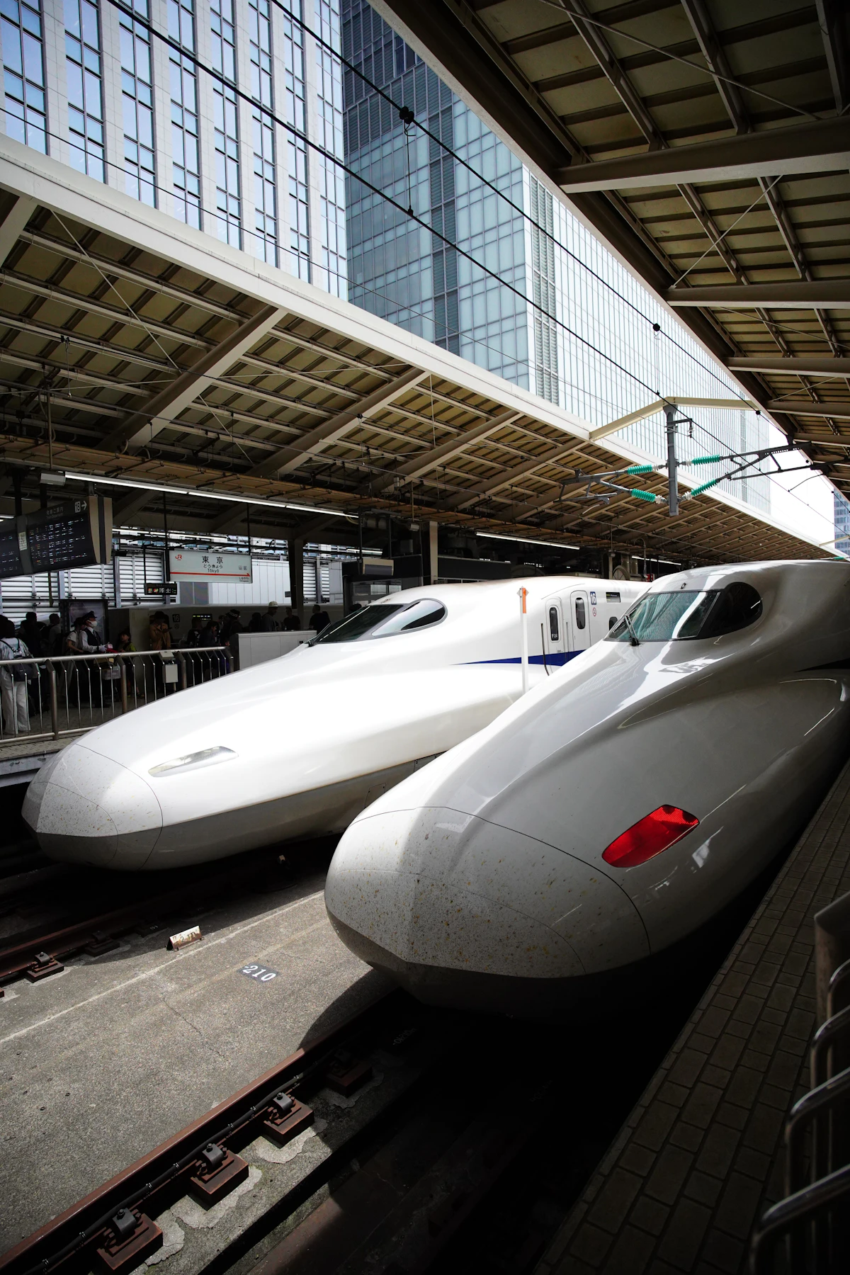 Two shinkansen trains side by side at a platform