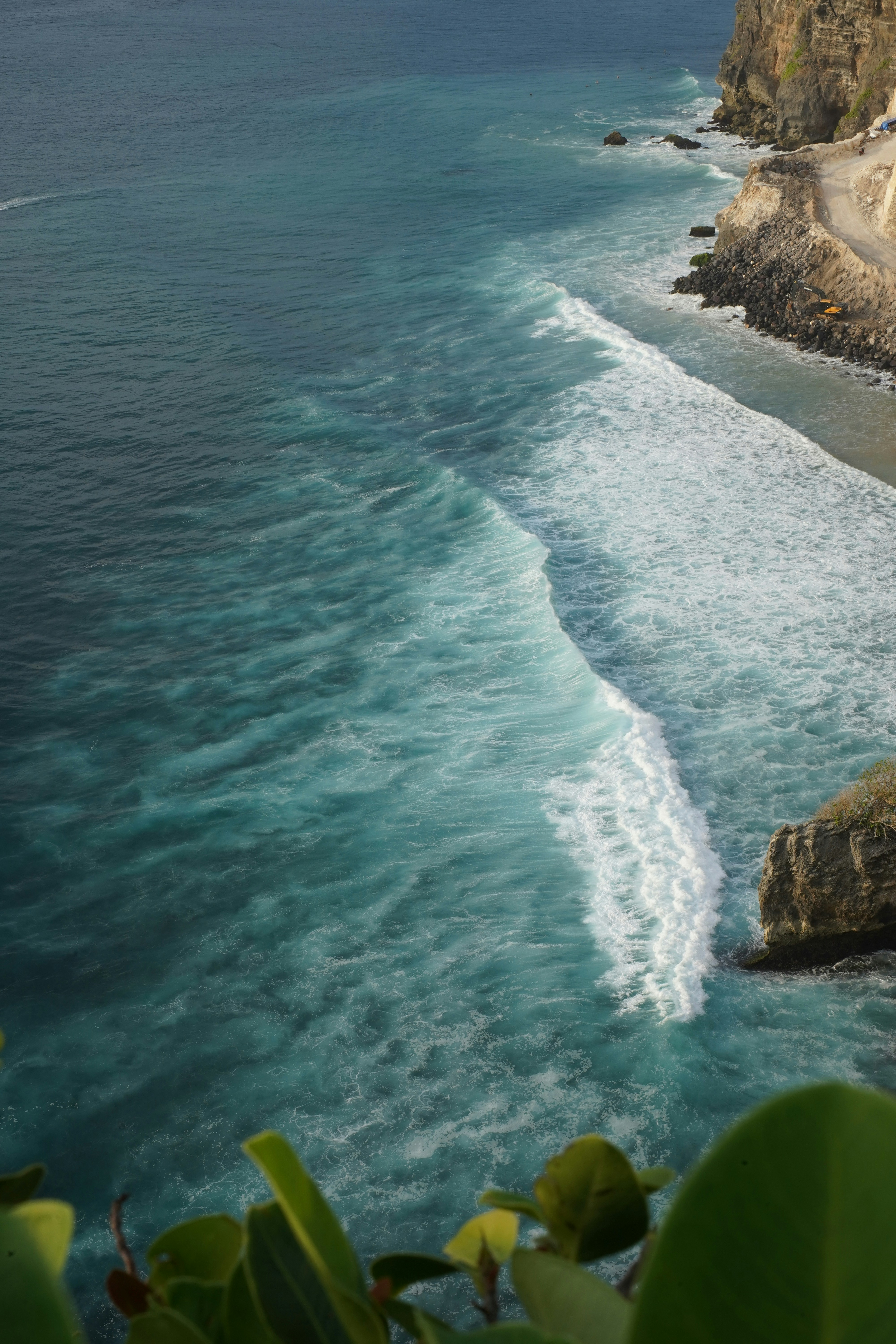 Ocean waves crash along a scenic shoreline.