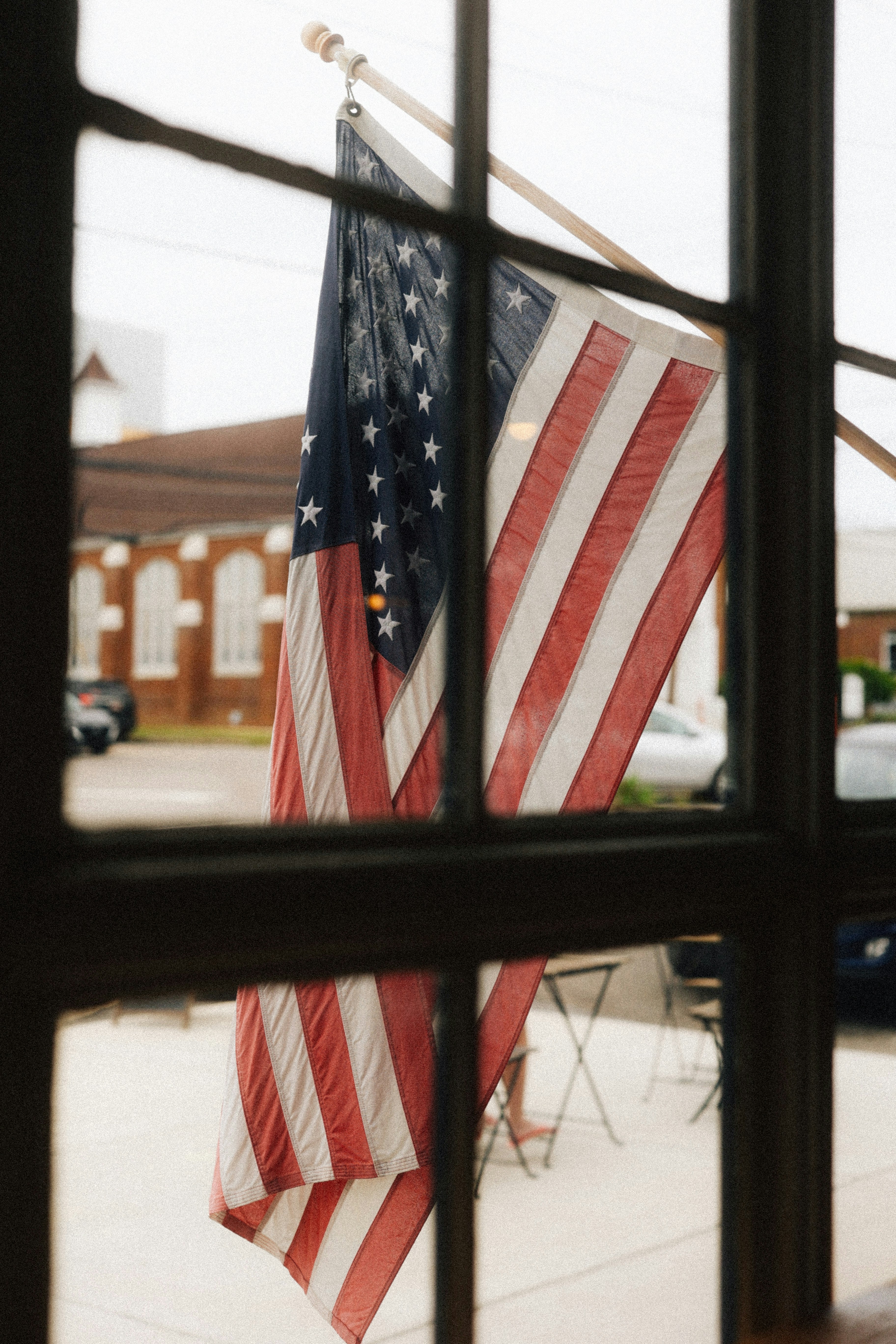 The american flag hangs in a window