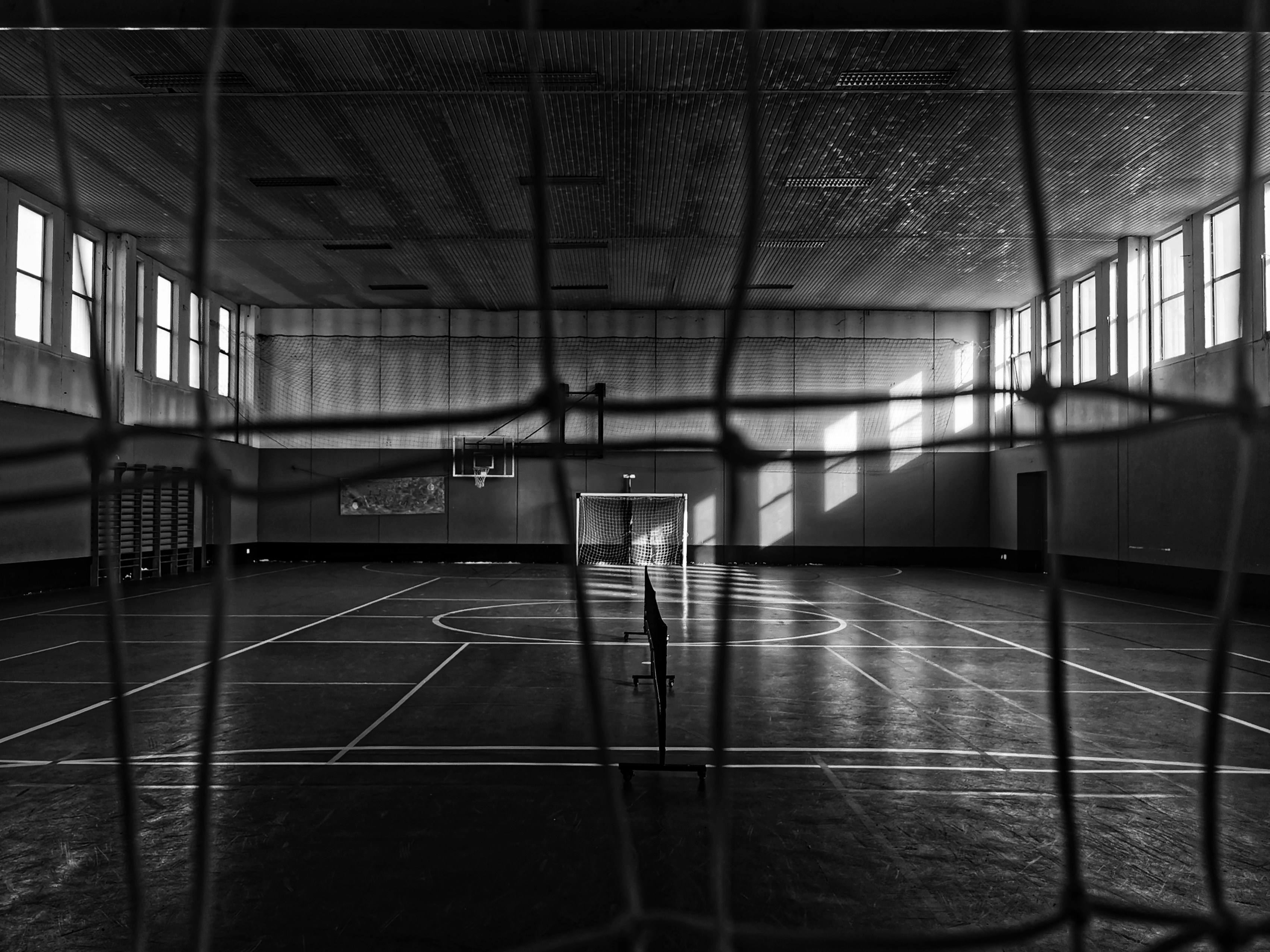 A grungy gym is viewed through the net.