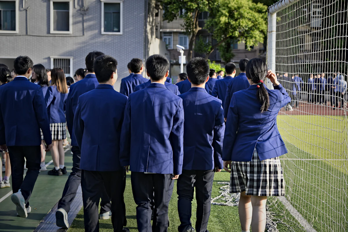 Siswa berseragam berjalan berkelompok di lapangan olahraga sekolah
