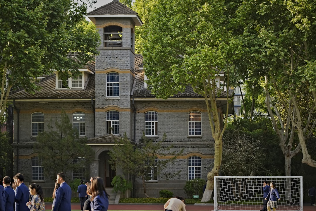 Students are on the school grounds near a historic building.