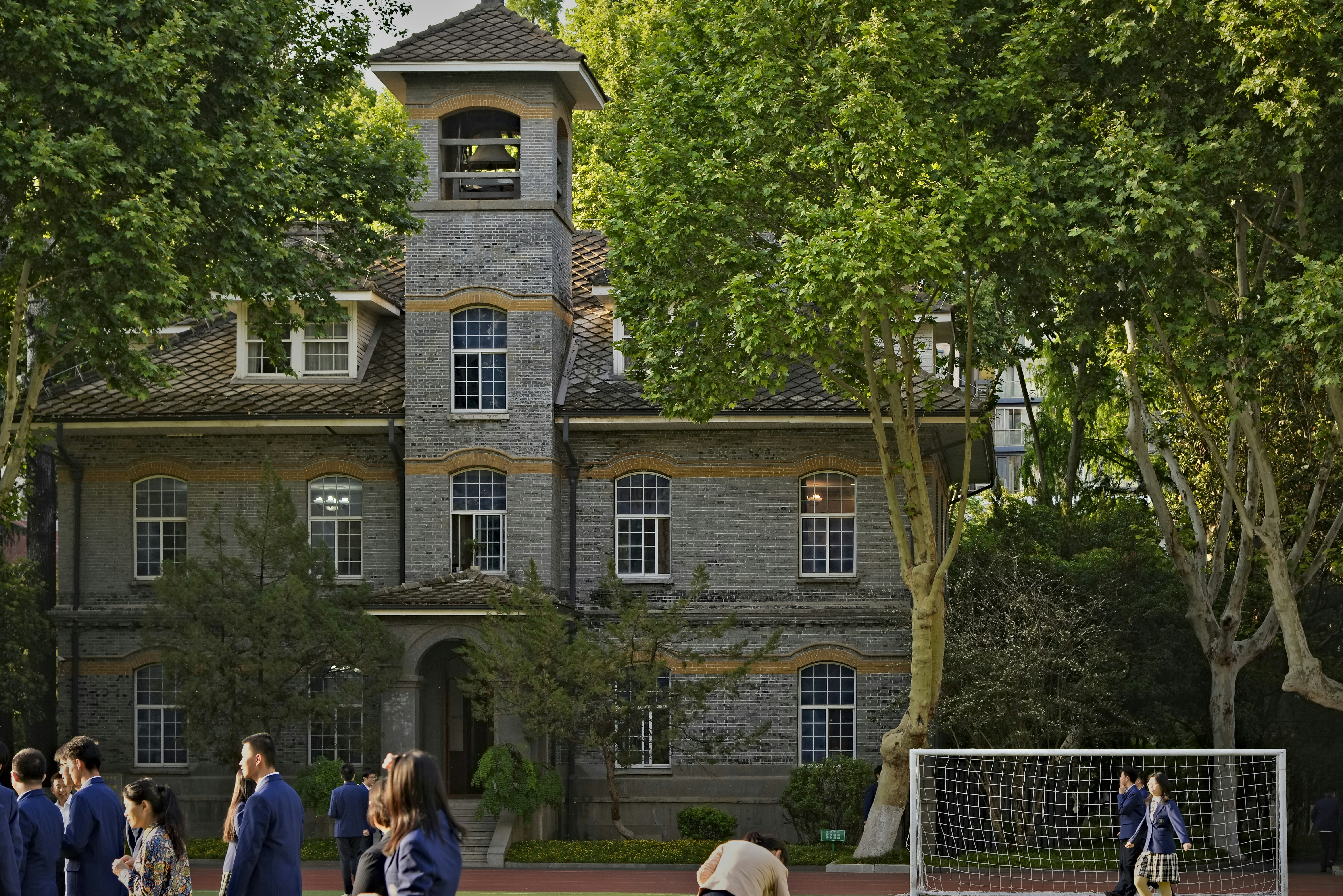 Students are on the school grounds near a historic building