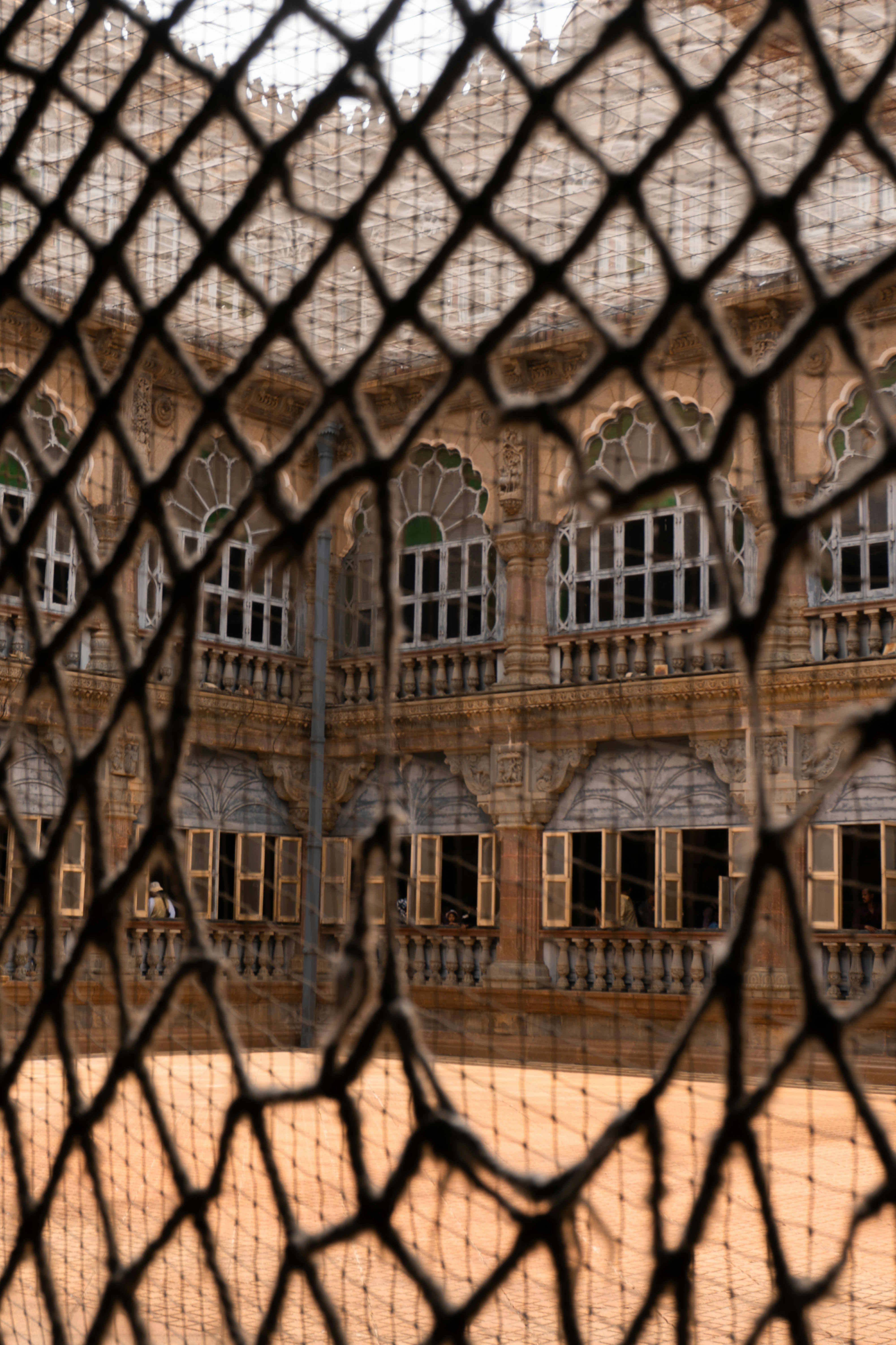 The beautiful building is seen through a net.