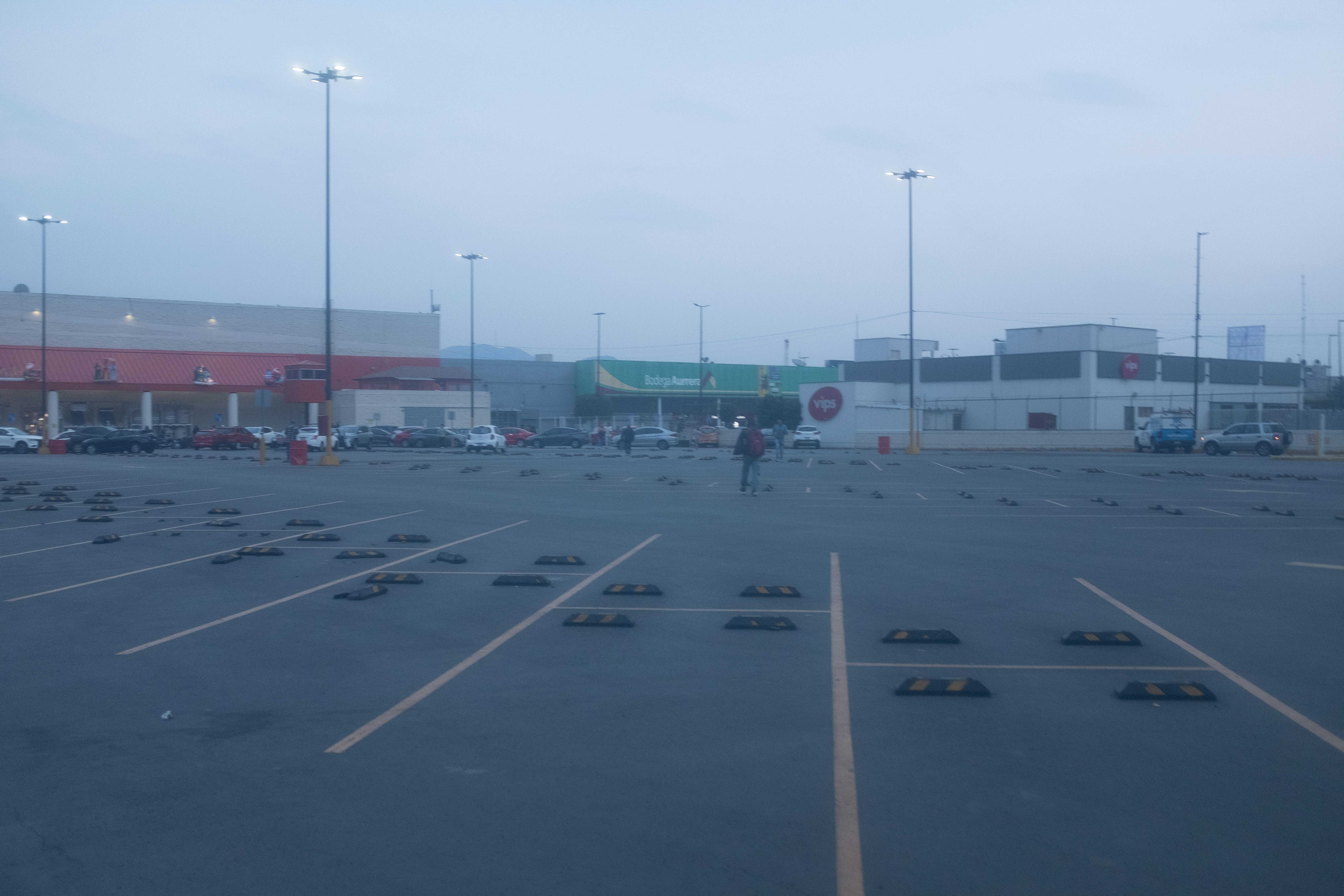 Empty parking lot with buildings in the background.