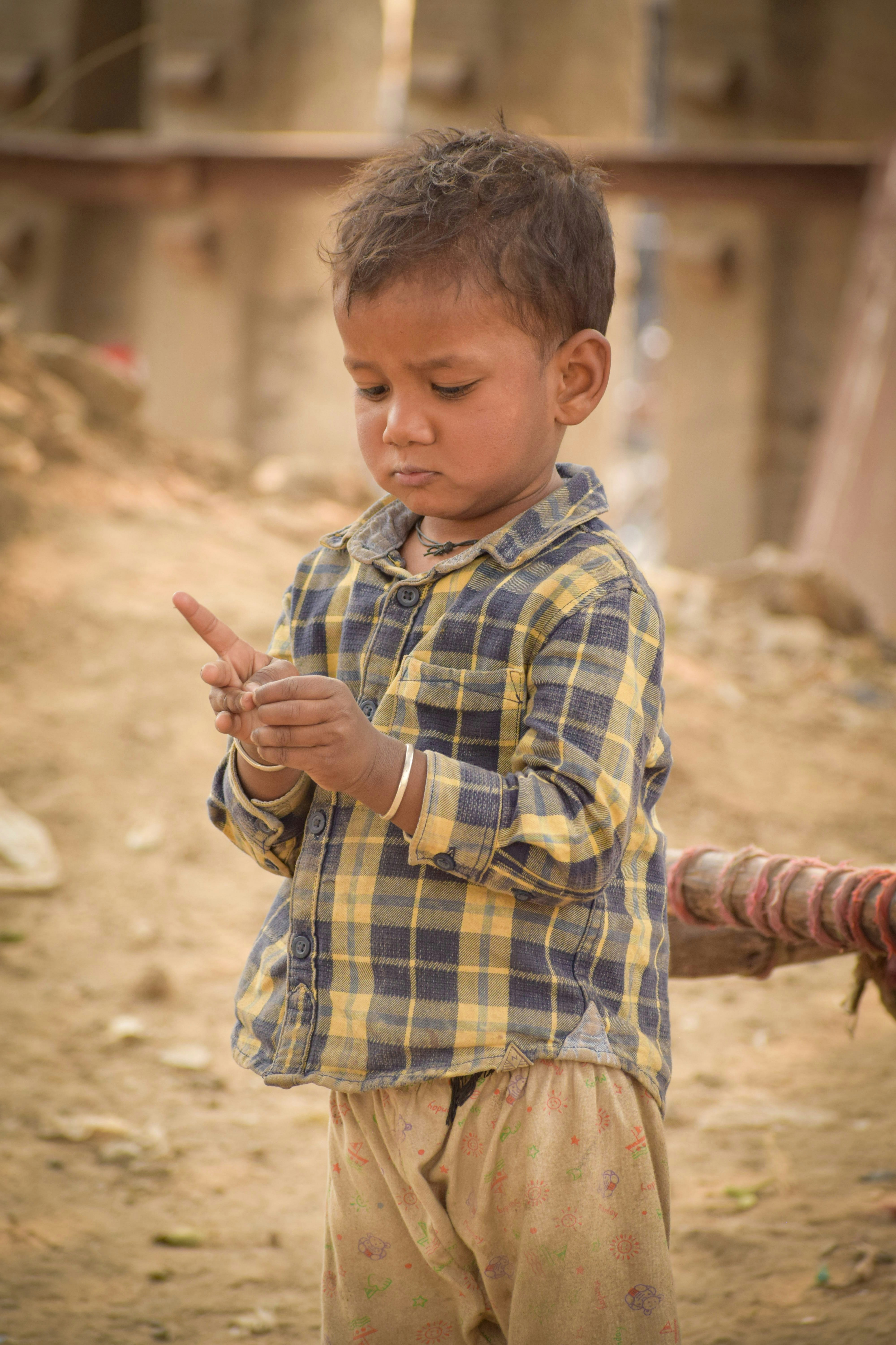 A young boy plays with something in his hands.