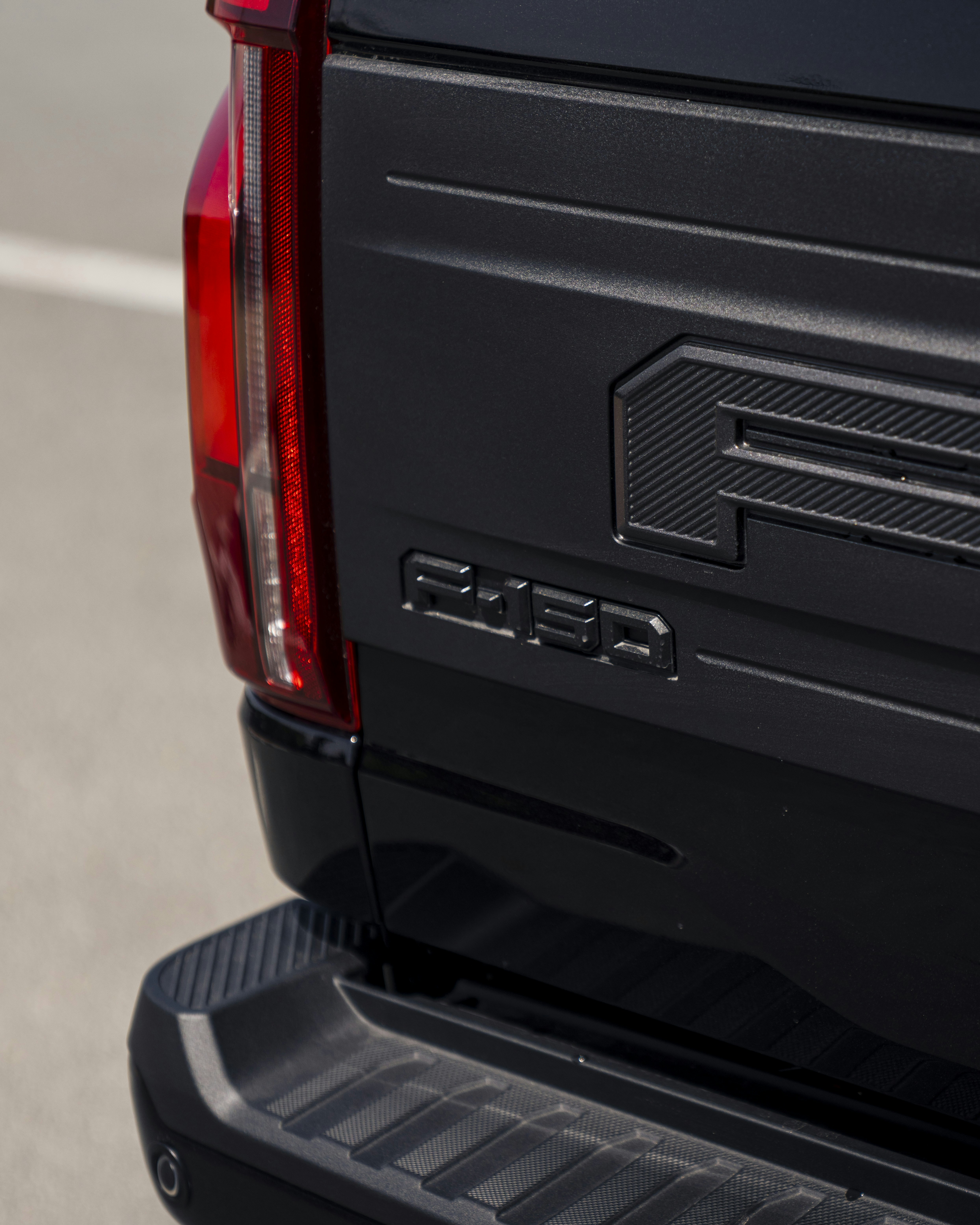 The rear of a black ford truck is shown.