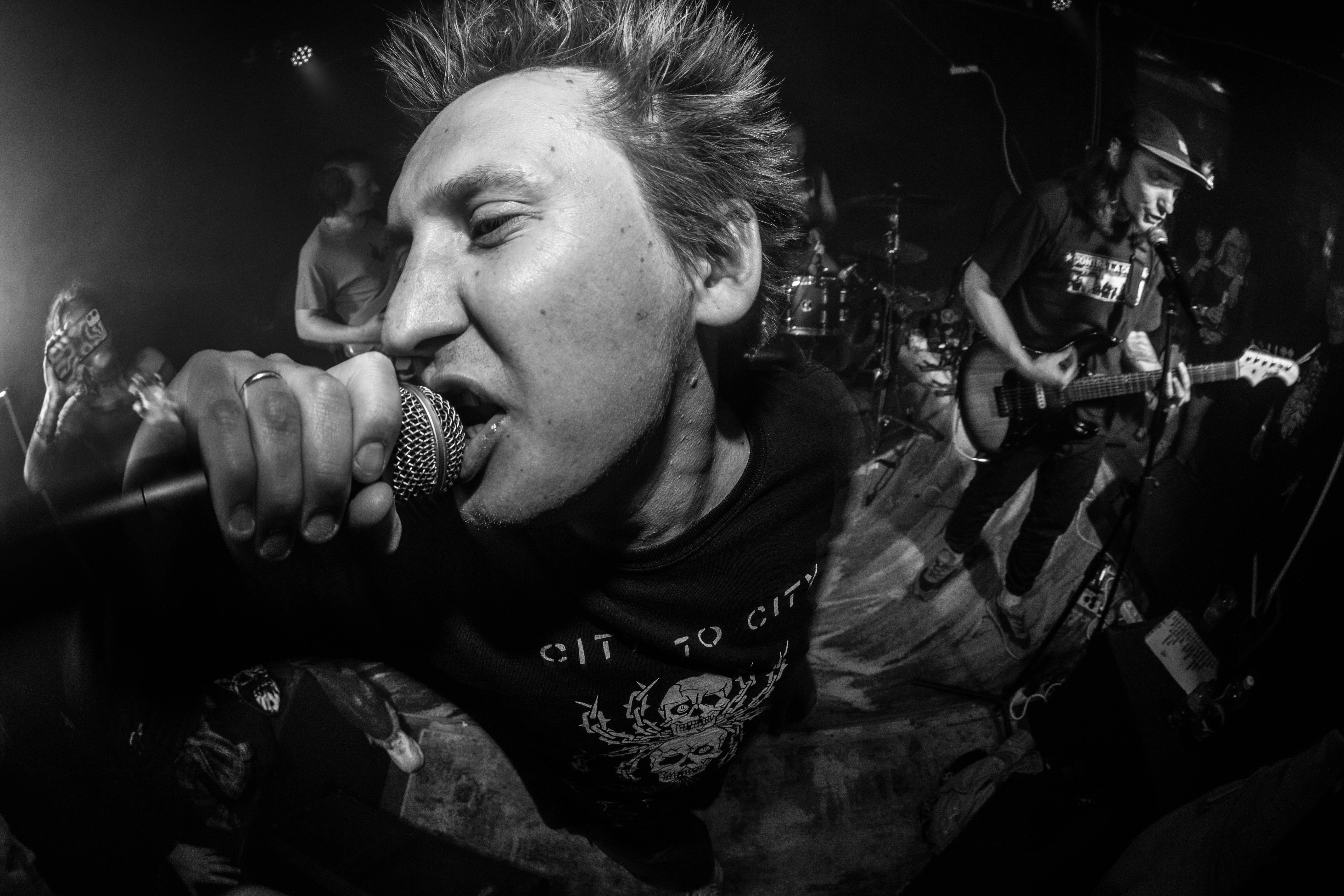 A punk rock singer performs on stage.