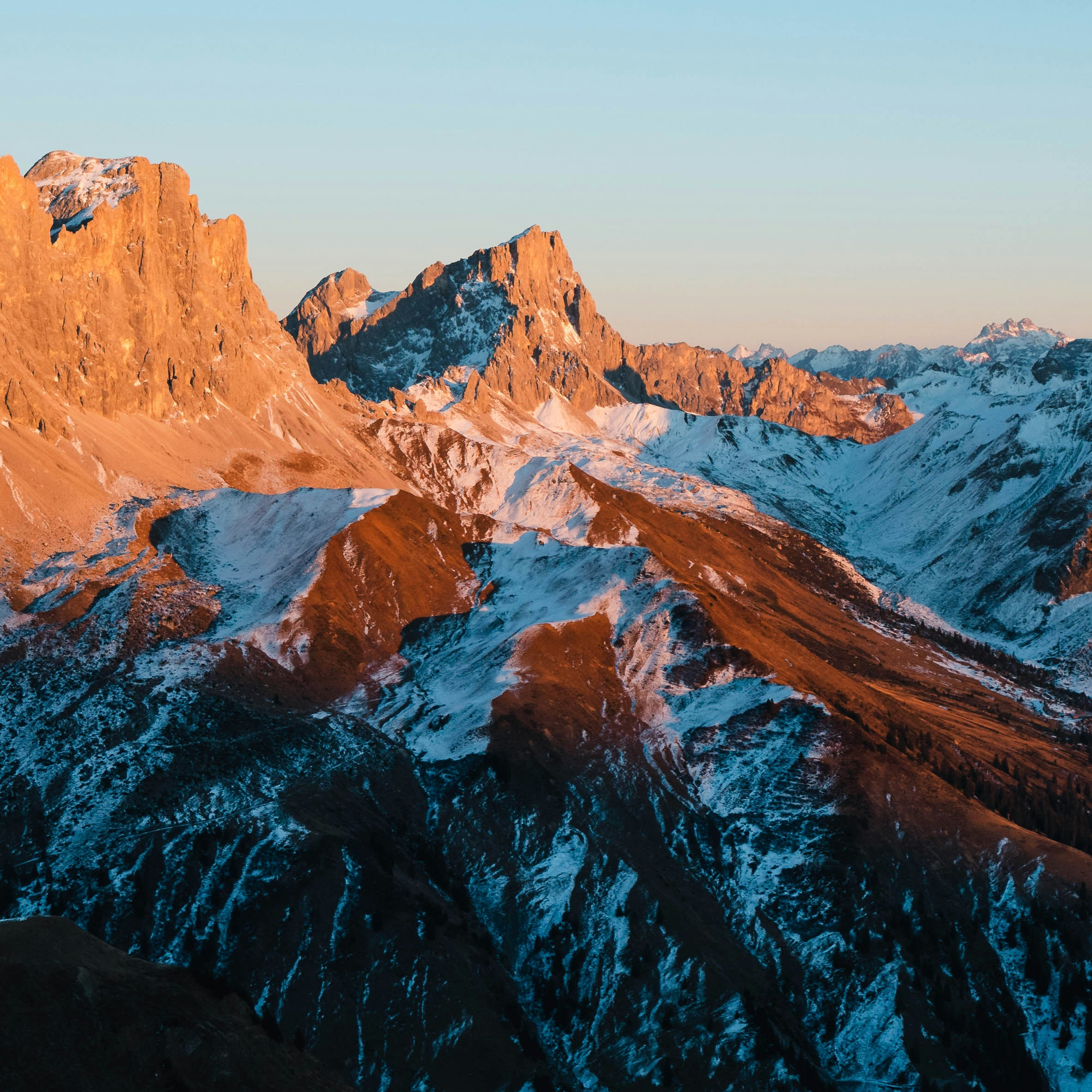 Snow-capped mountains glow in the morning light.