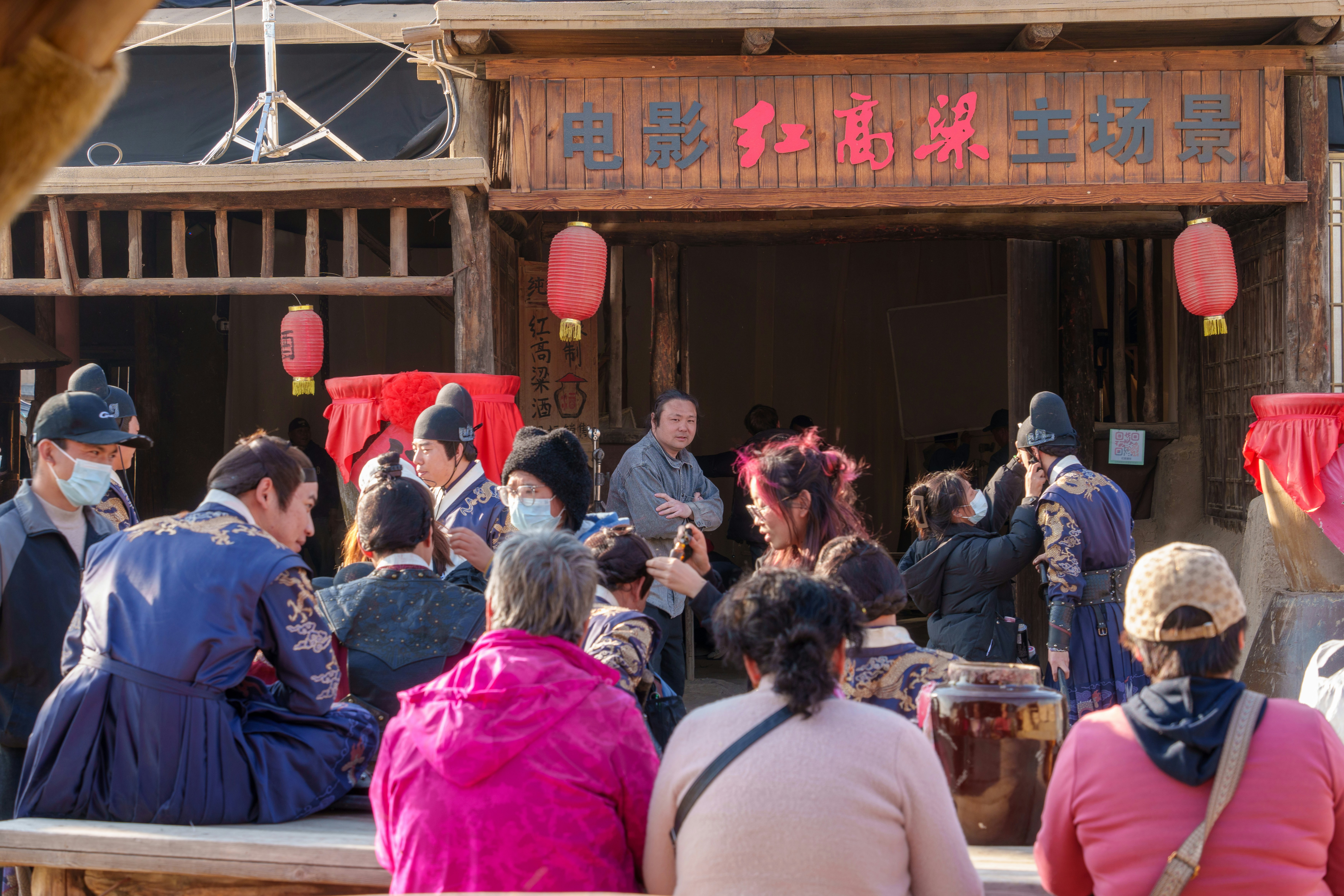 People gather at a film set in a historical village.