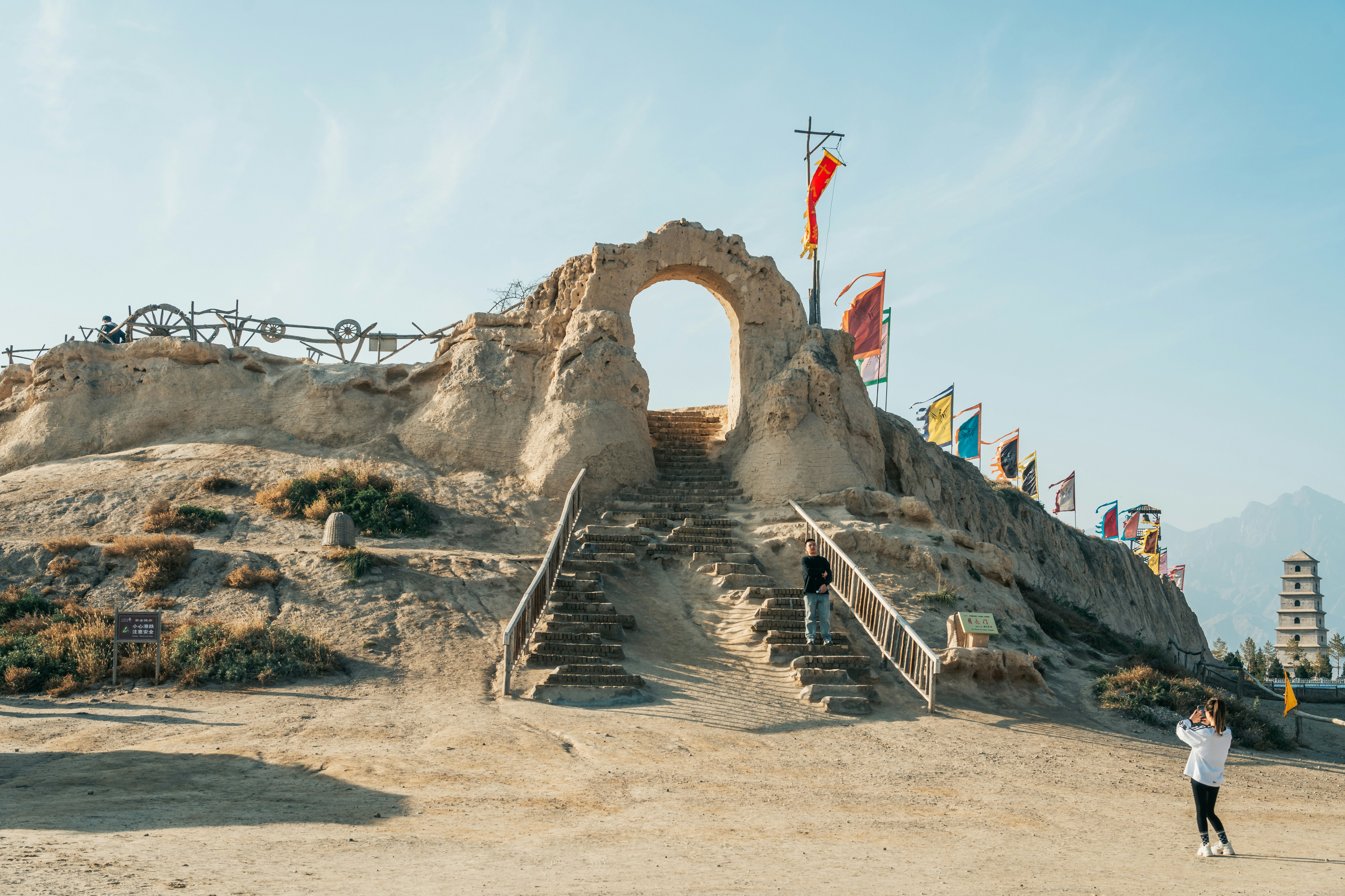 Ancient stone archway with stairs and flags.