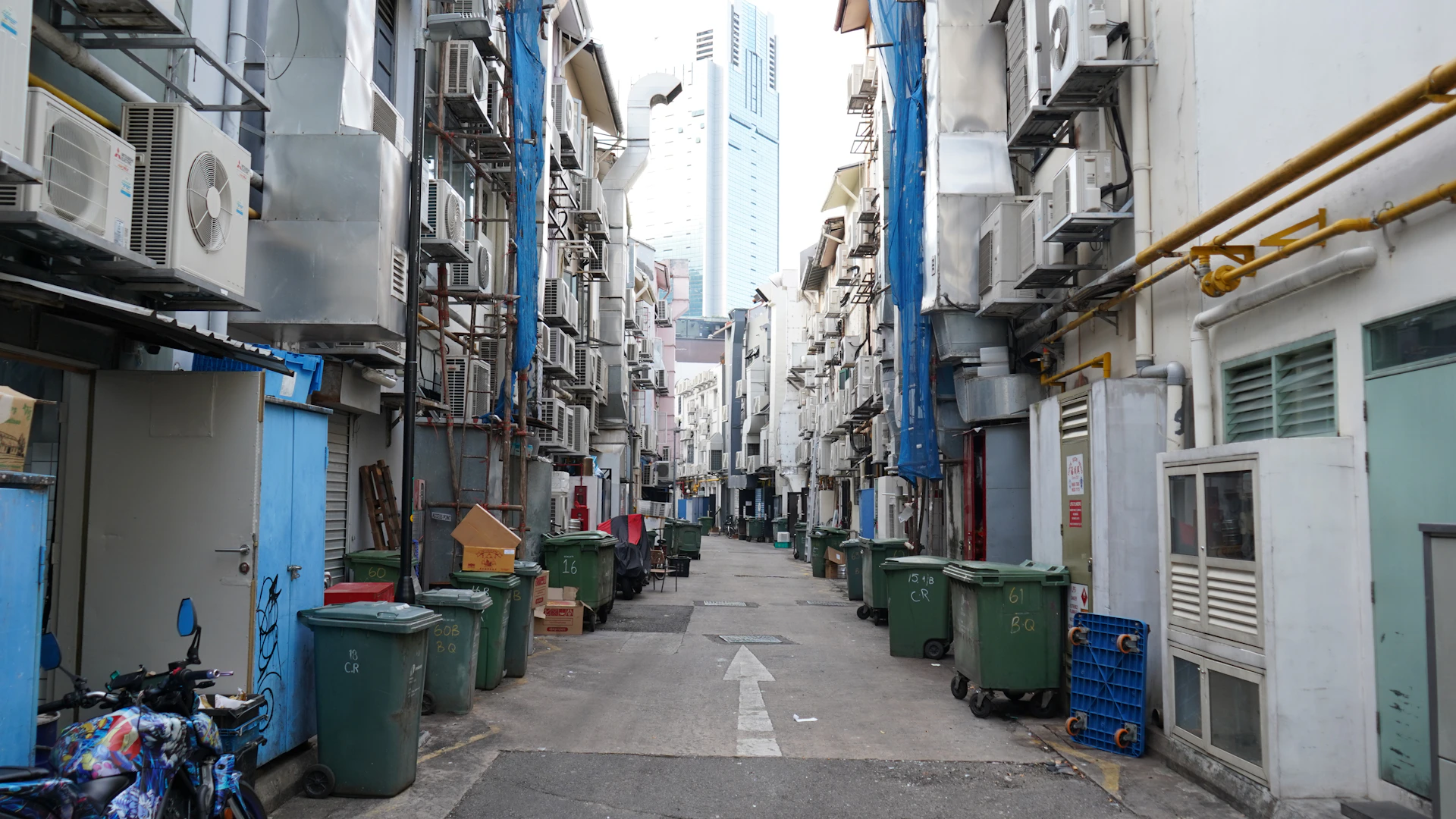 A narrow alley filled with trash cans.