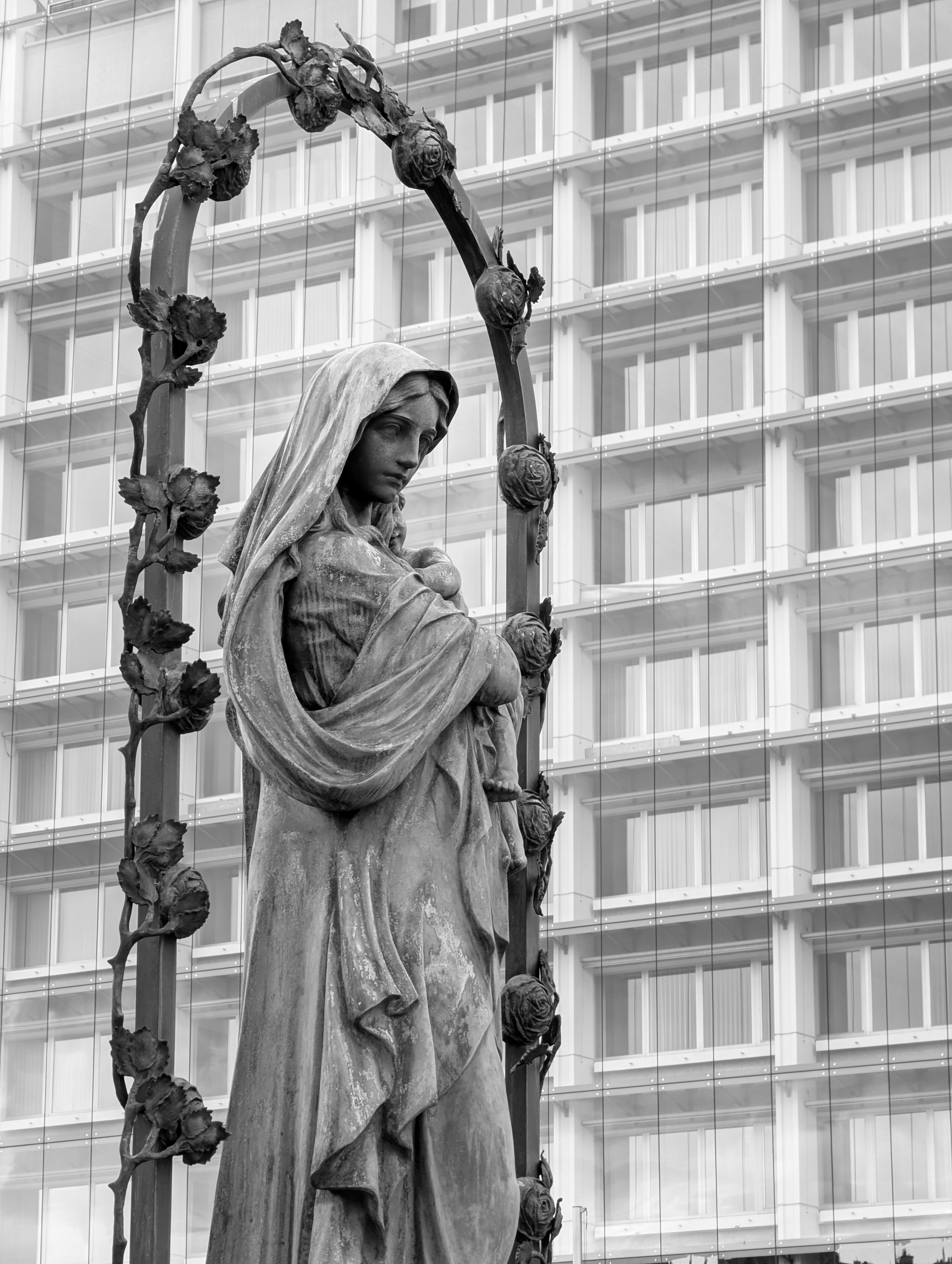 A statue of a woman stands before a building.
