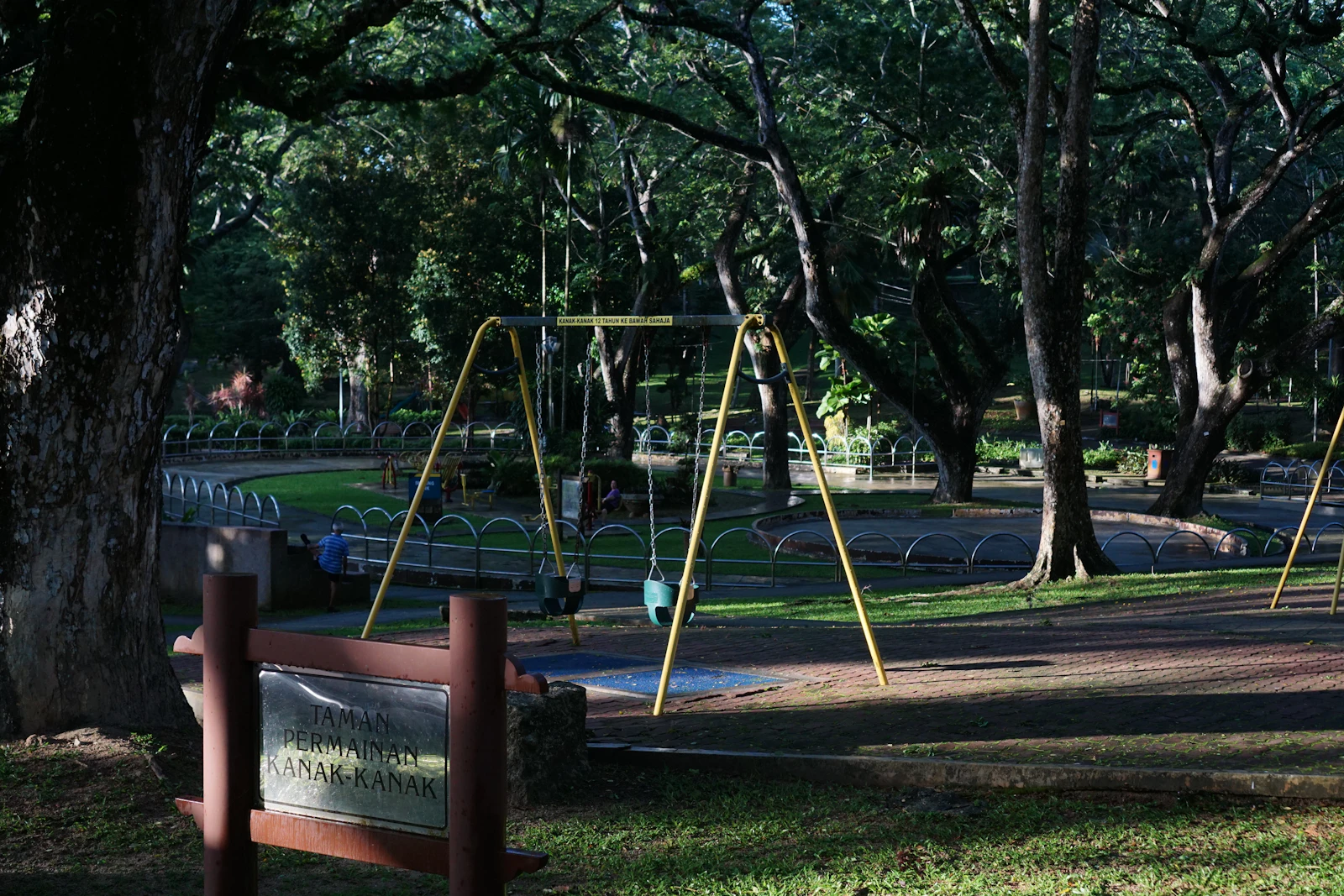 Playground com balanços em parque arborizado
