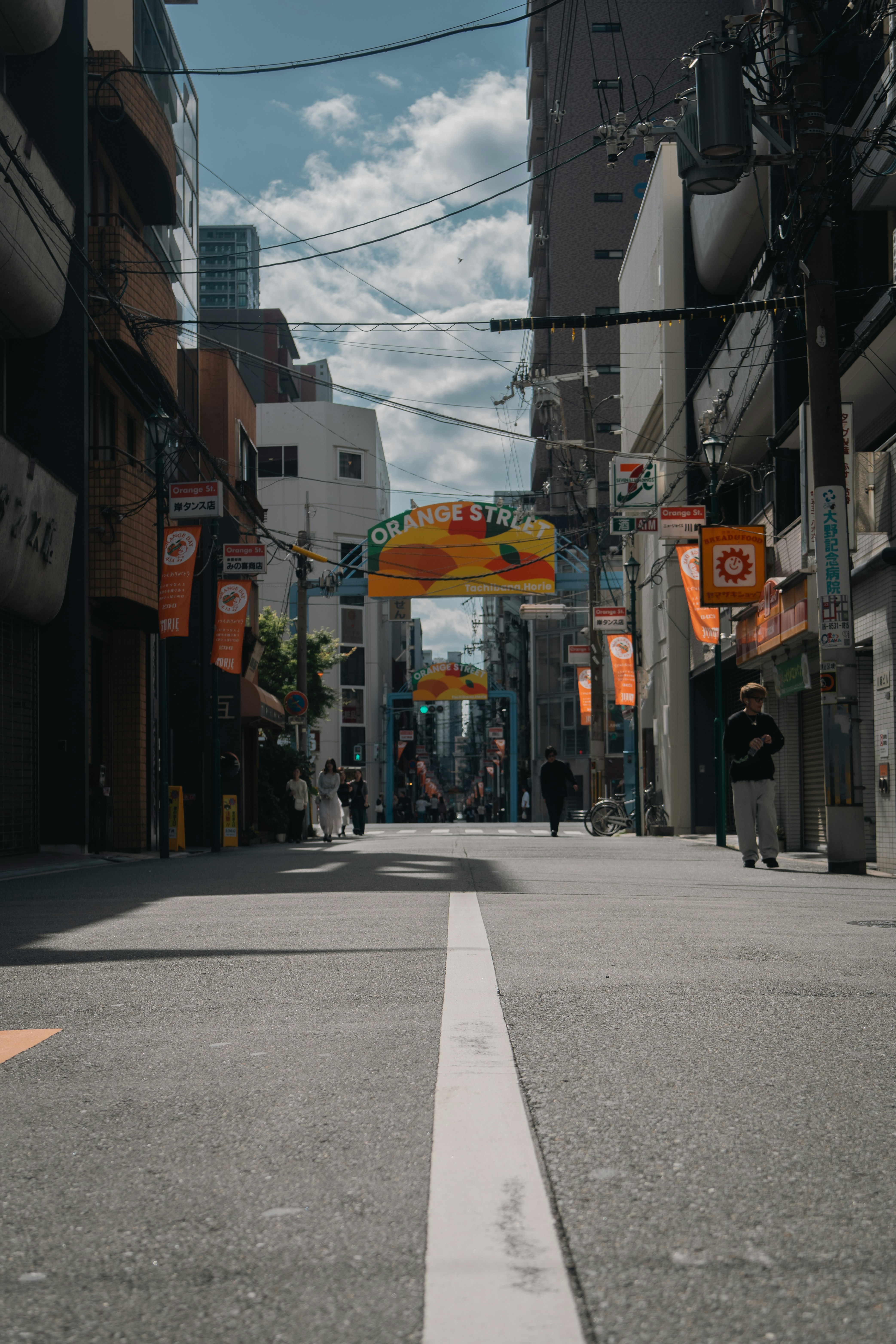 A city street is seen, lined by buildings.