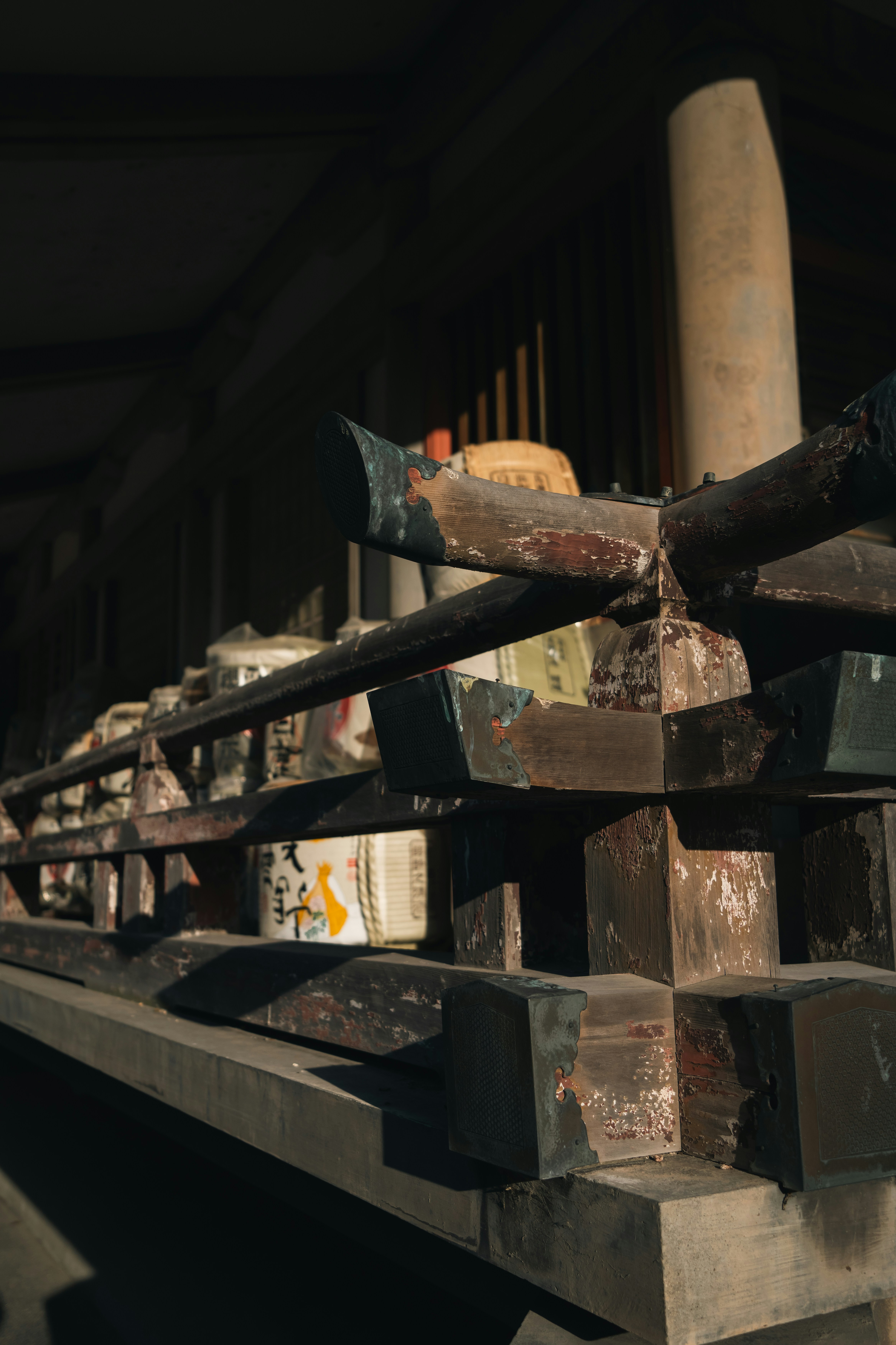 Wooden structure holds various objects in a dark room.