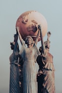 Statues hold up a large globe.
