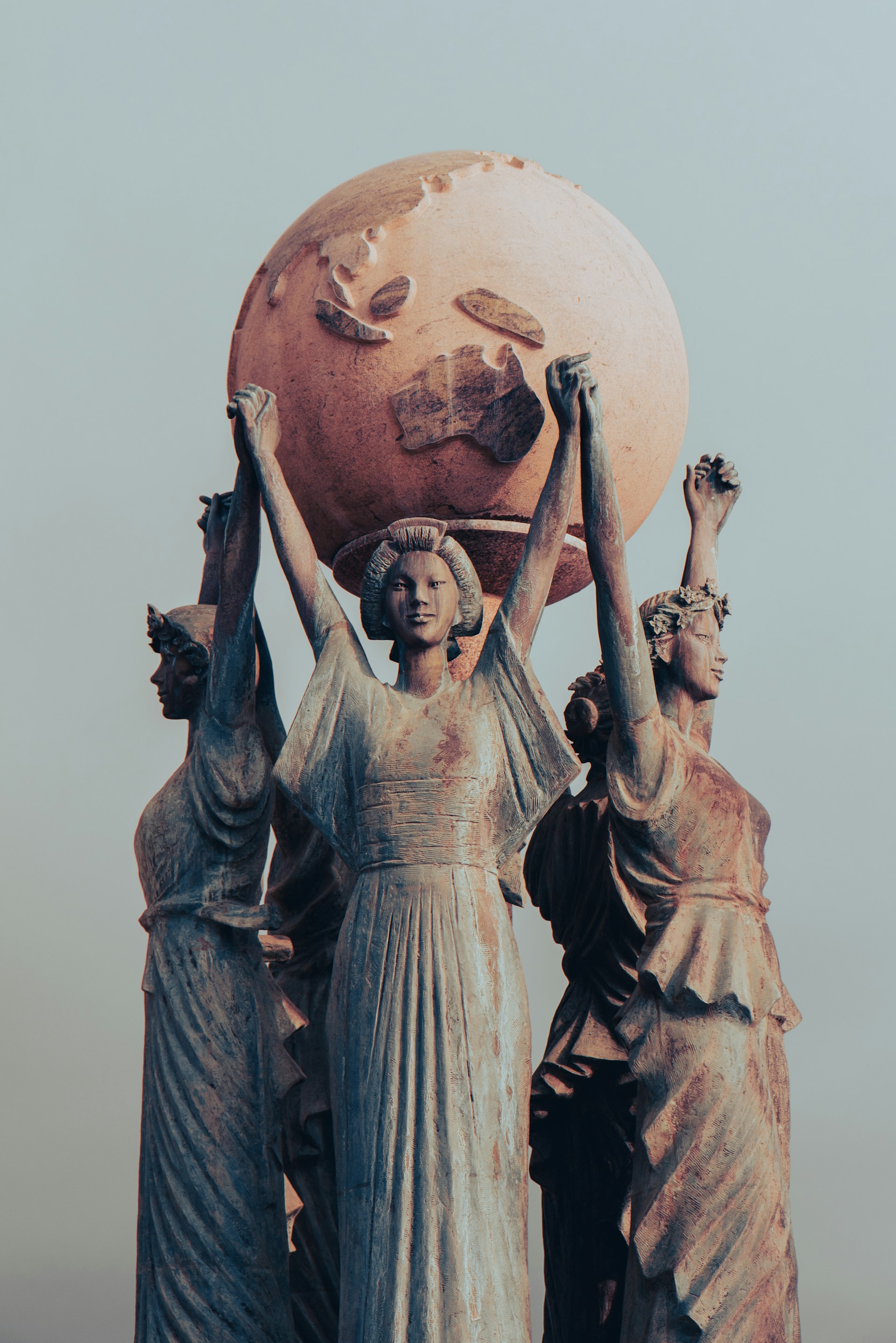 Statues hold up a large globe.