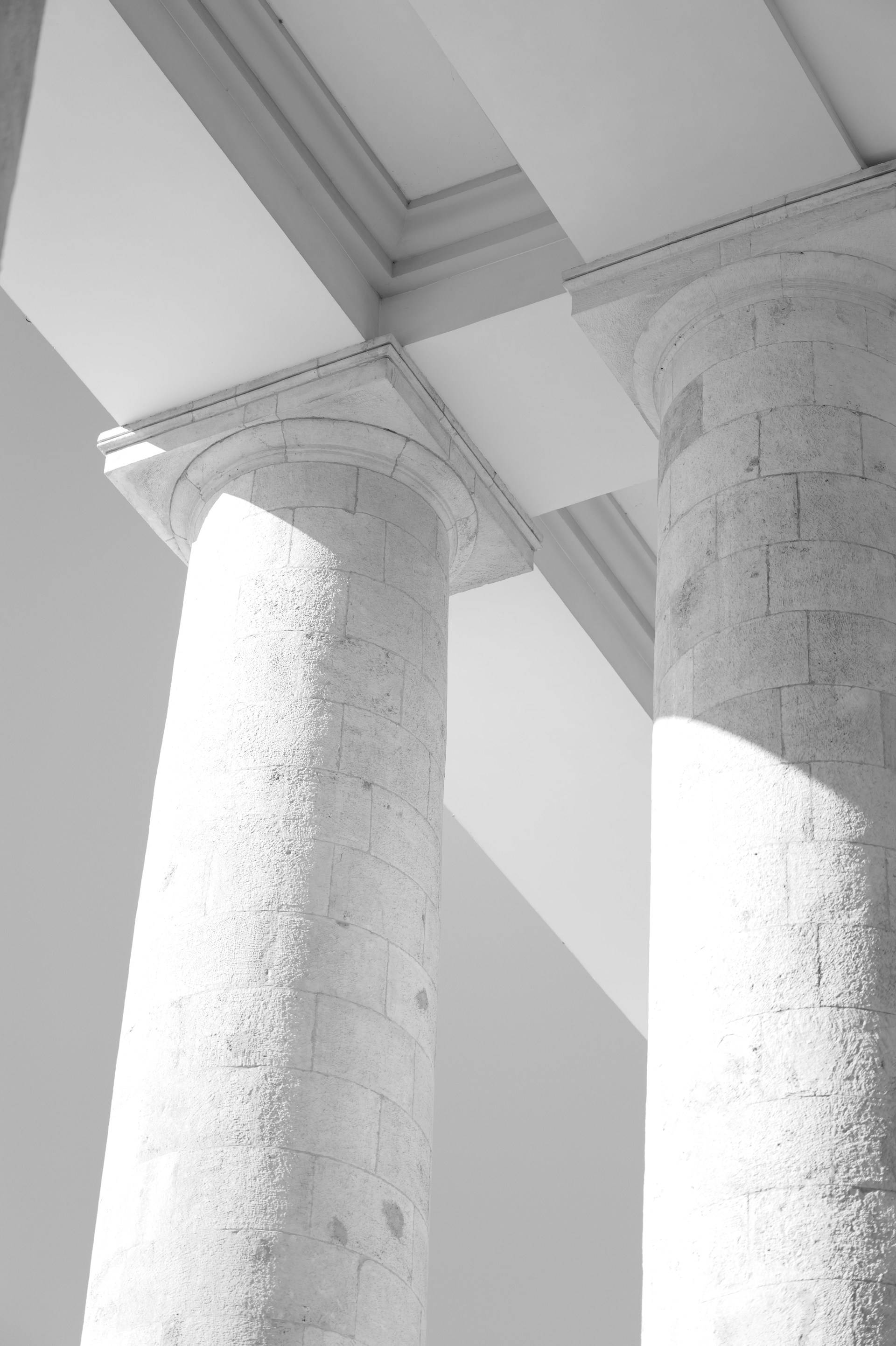 Stone columns support a bright, white ceiling.