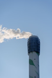 Smoke puffs from a tall industrial chimney.
