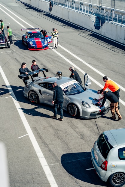 Race cars are being prepared in the pit lane.
