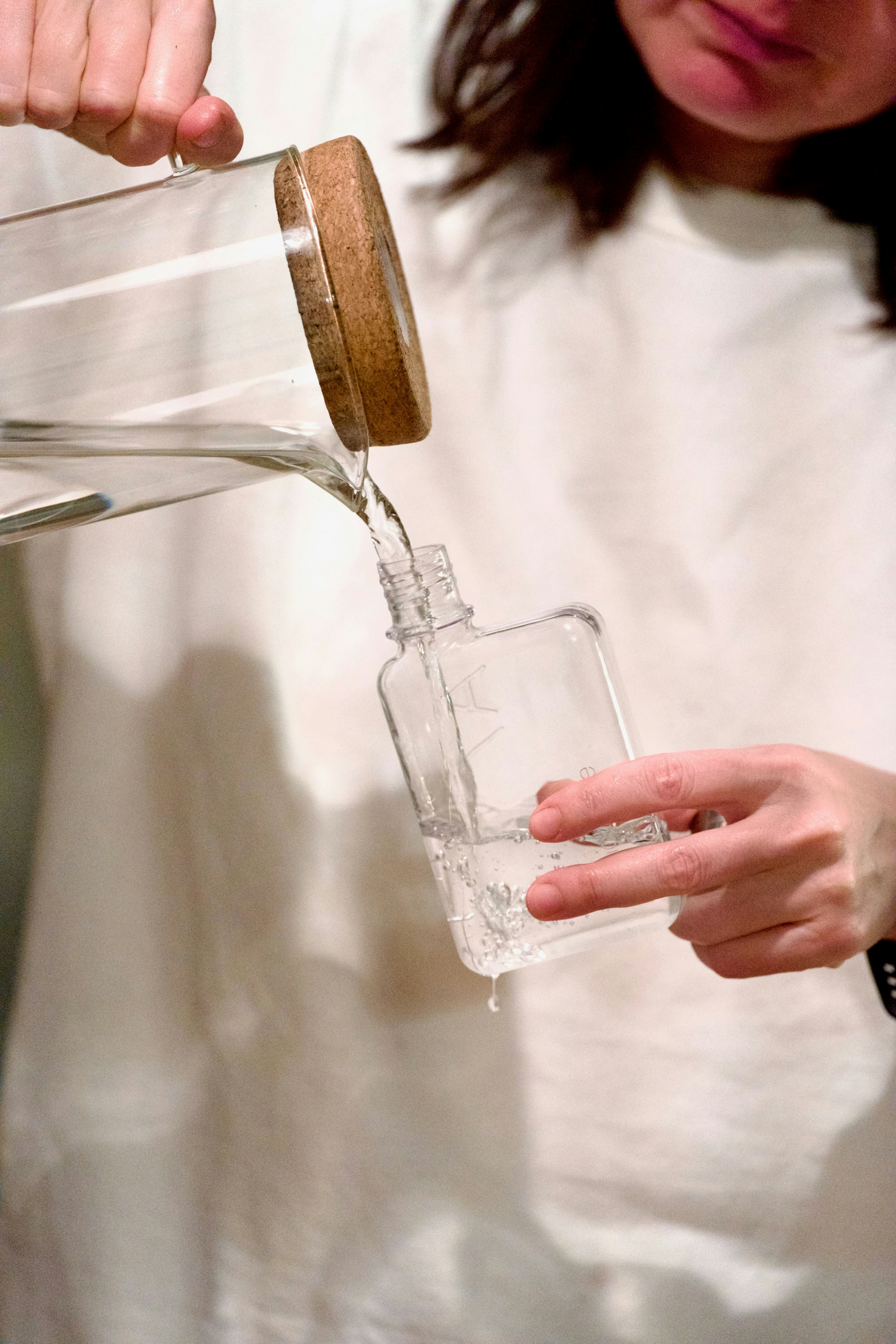 Someone is pouring water into a bottle.