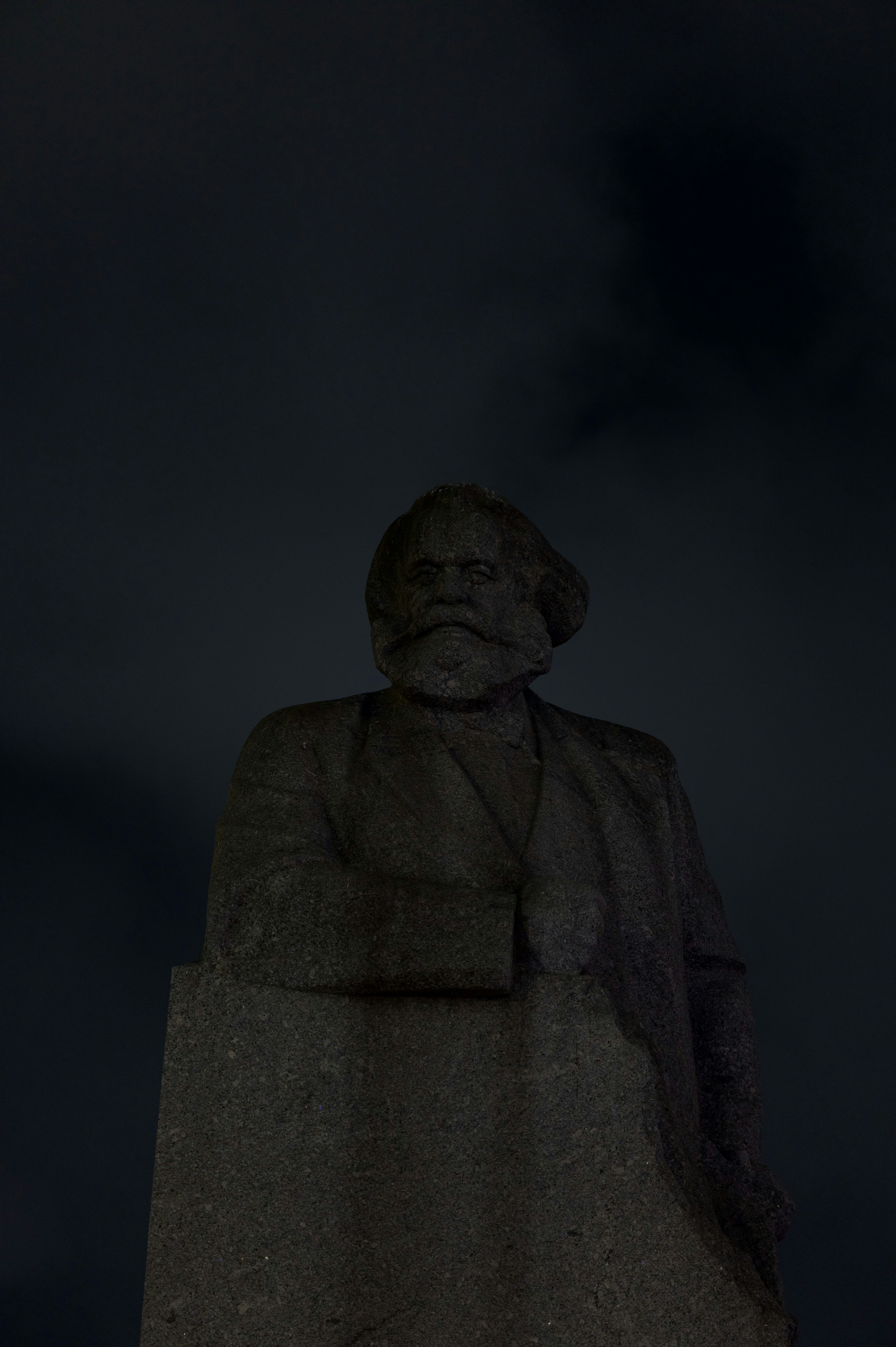 Monumental statue of a historical figure, shrouded in night, exuding a sense of solemnity and reflection.