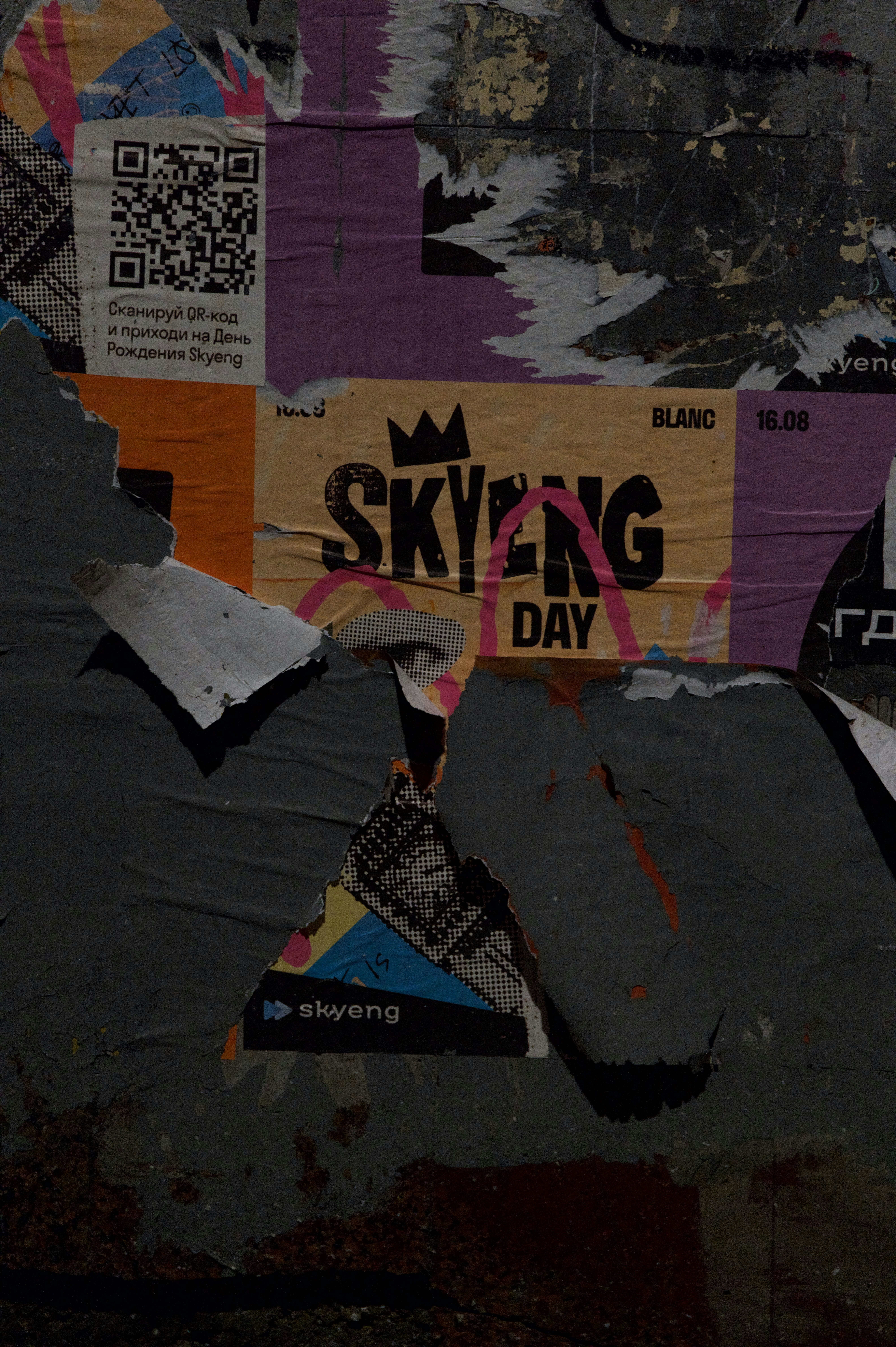 Torn posters advertise a "skyeng day" event.