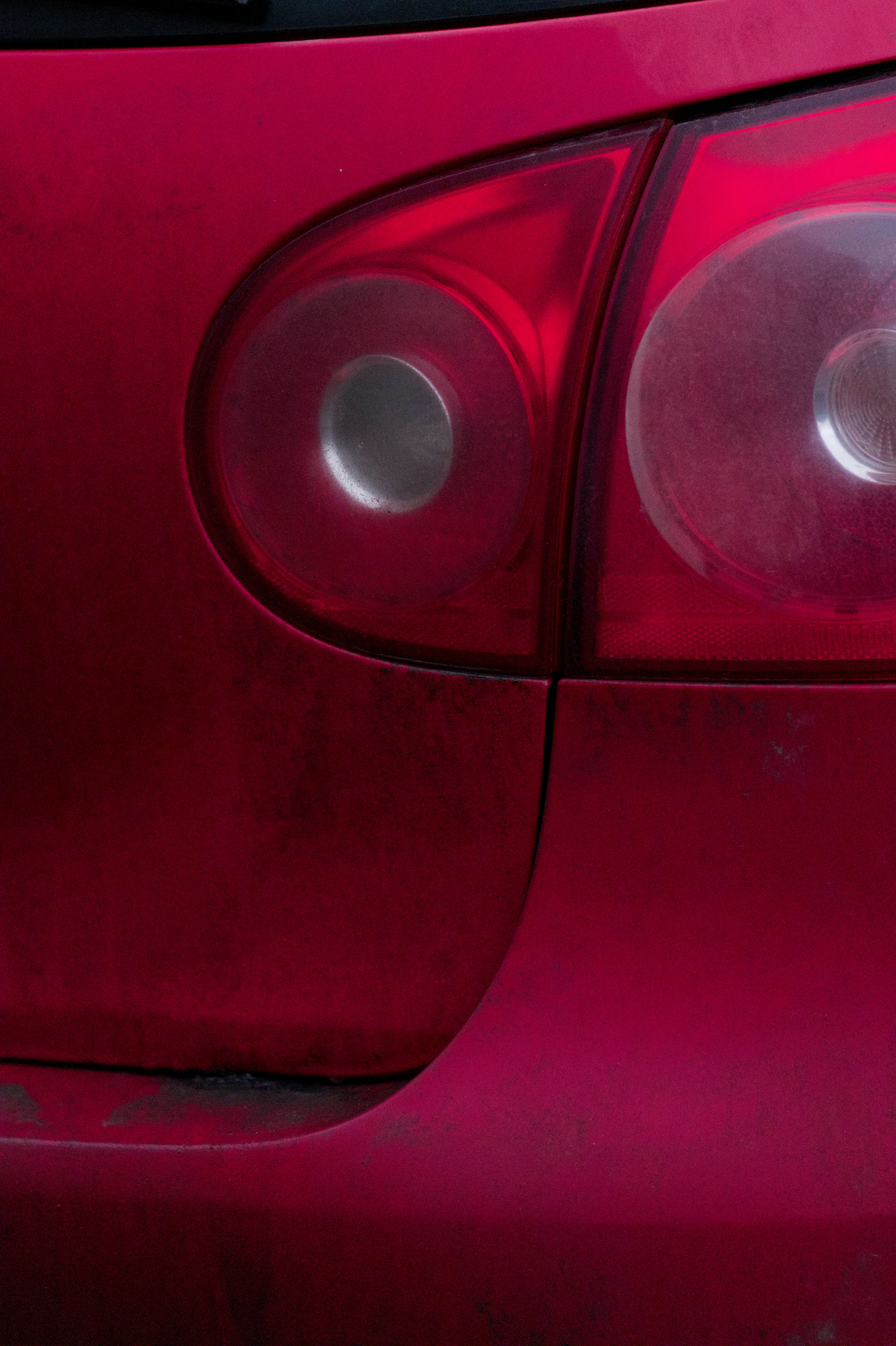 The close-up shows a red car's taillight.