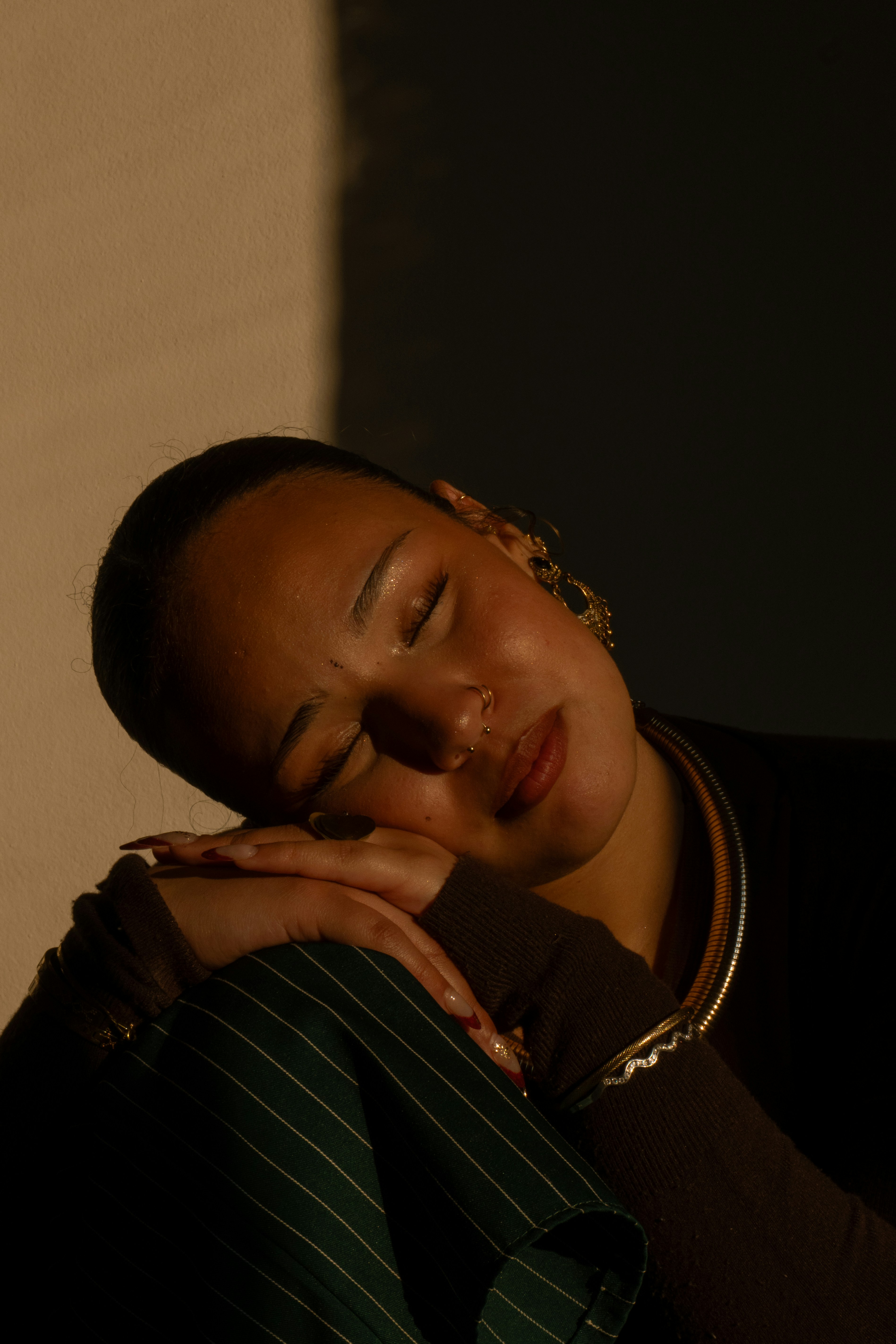 Woman rests, eyes closed, illuminated by light.