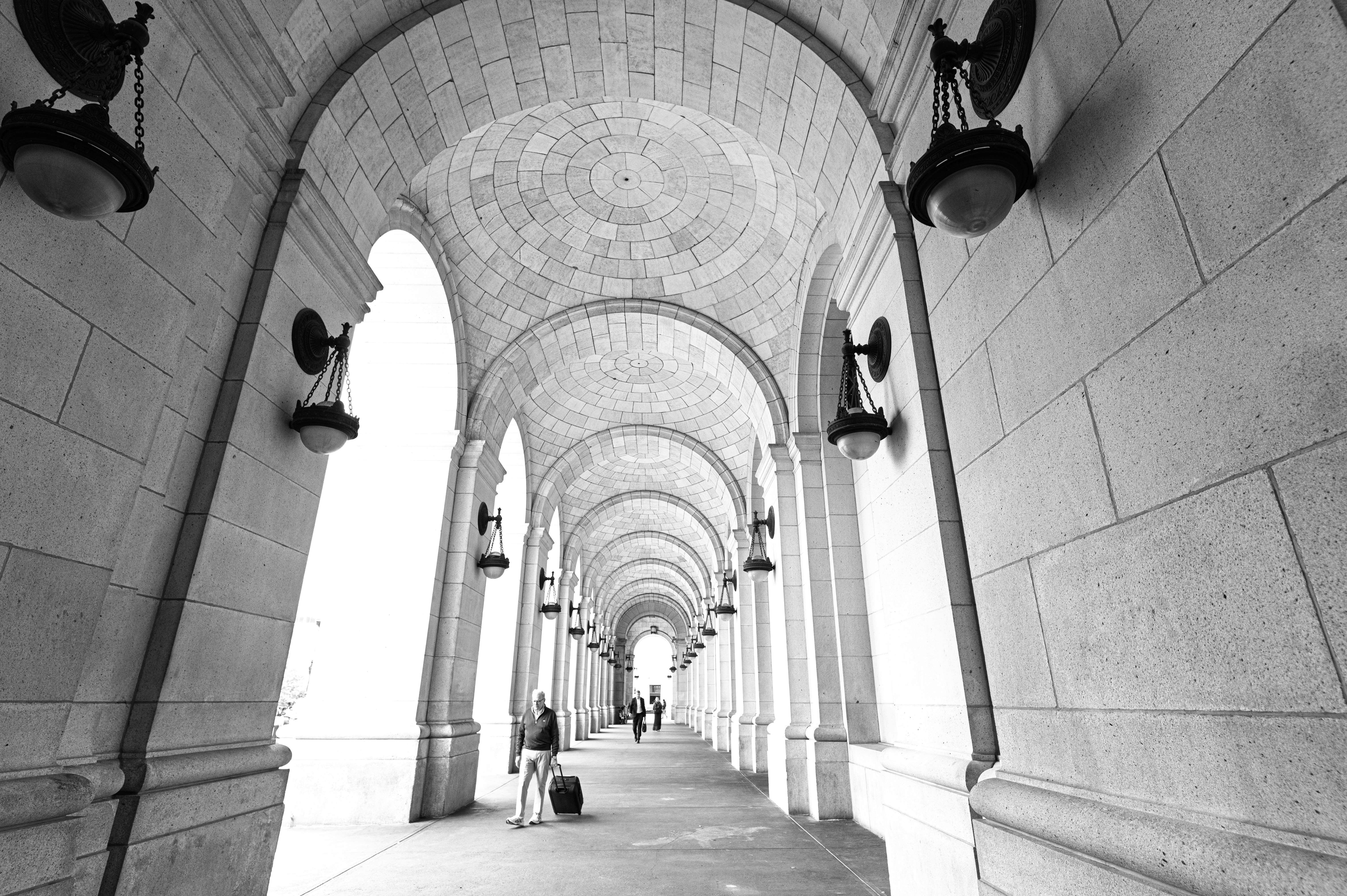 A long, arched hallway with light fixtures.