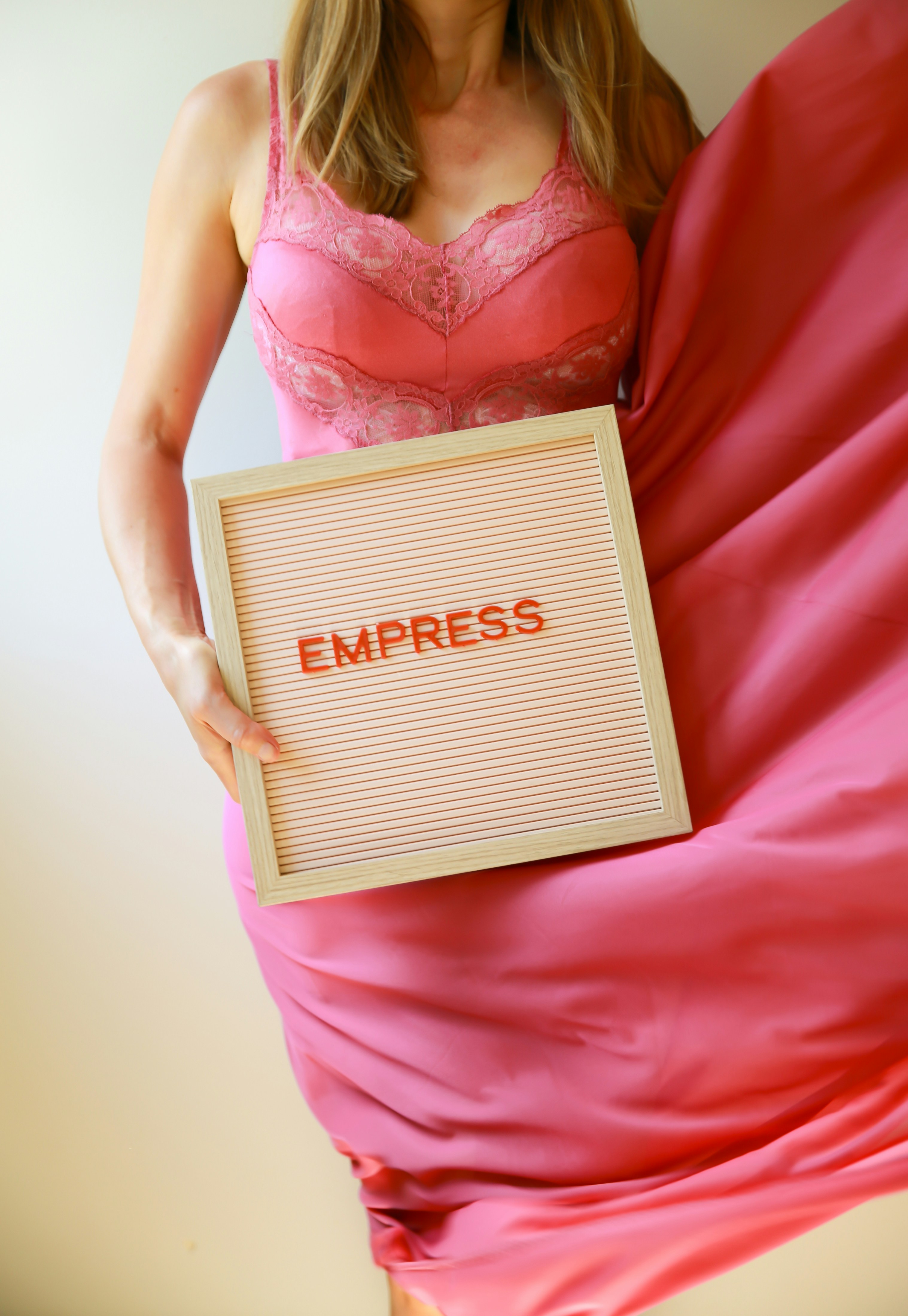 Woman holds a sign that says "empress."