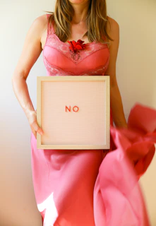 A woman holds a sign that says "no".