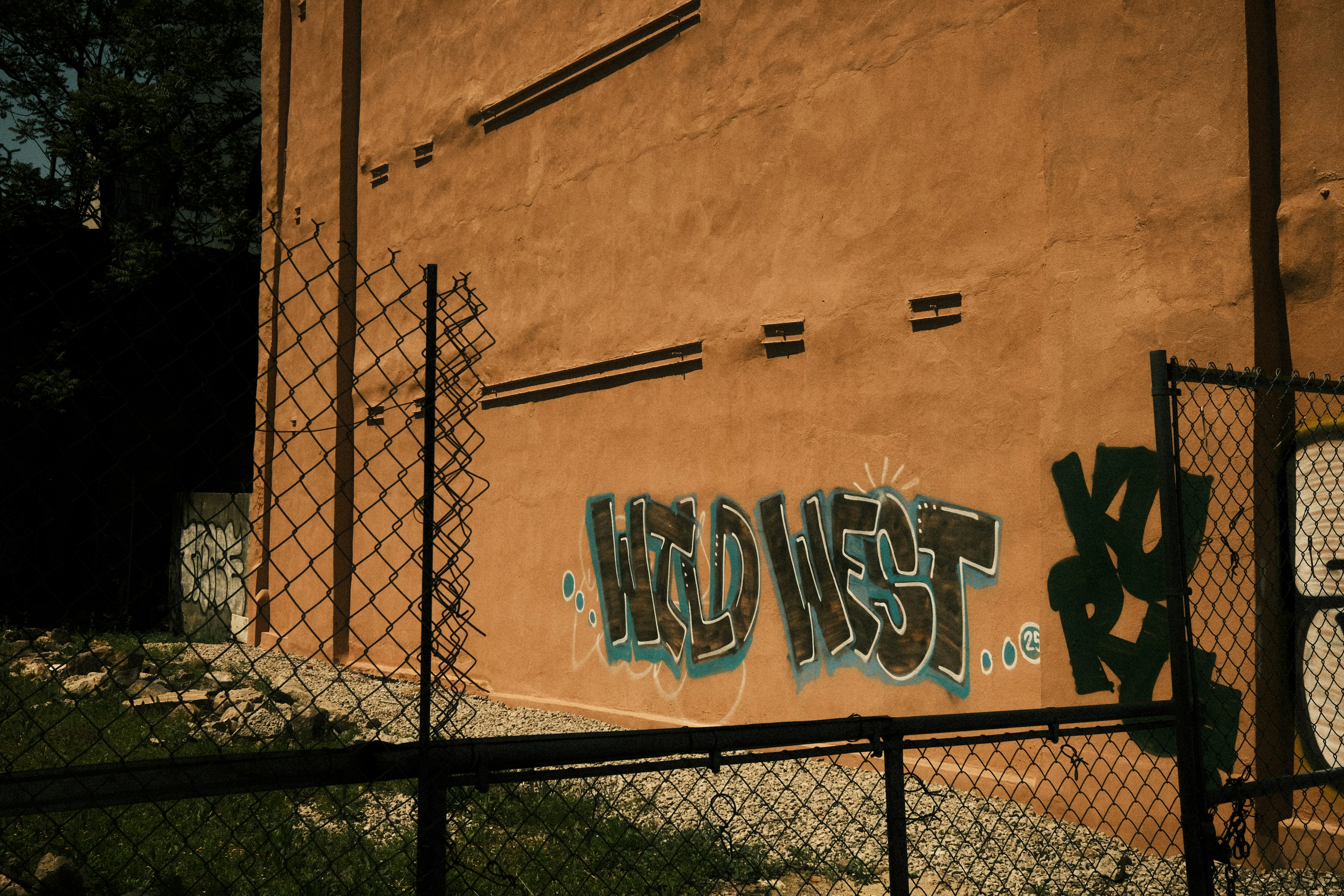 Grafiti bertuliskan "barat liar" di sebuah bangunan bata.