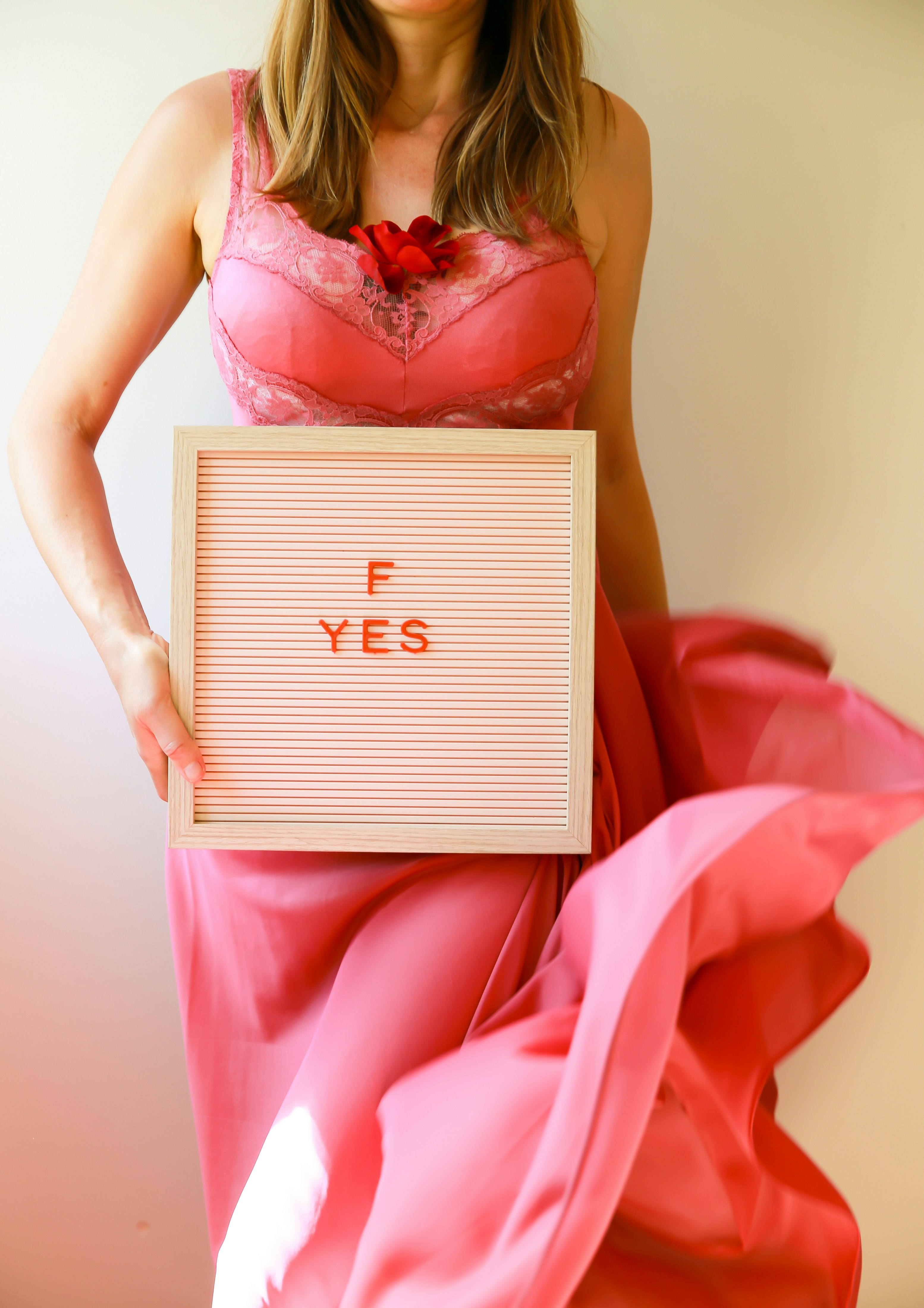 Woman holds a sign that says "f yes."