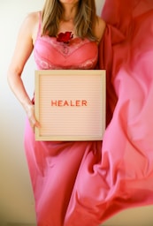 Woman holds sign that says "healer".