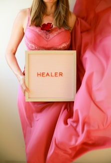 Woman holds sign that says "healer".