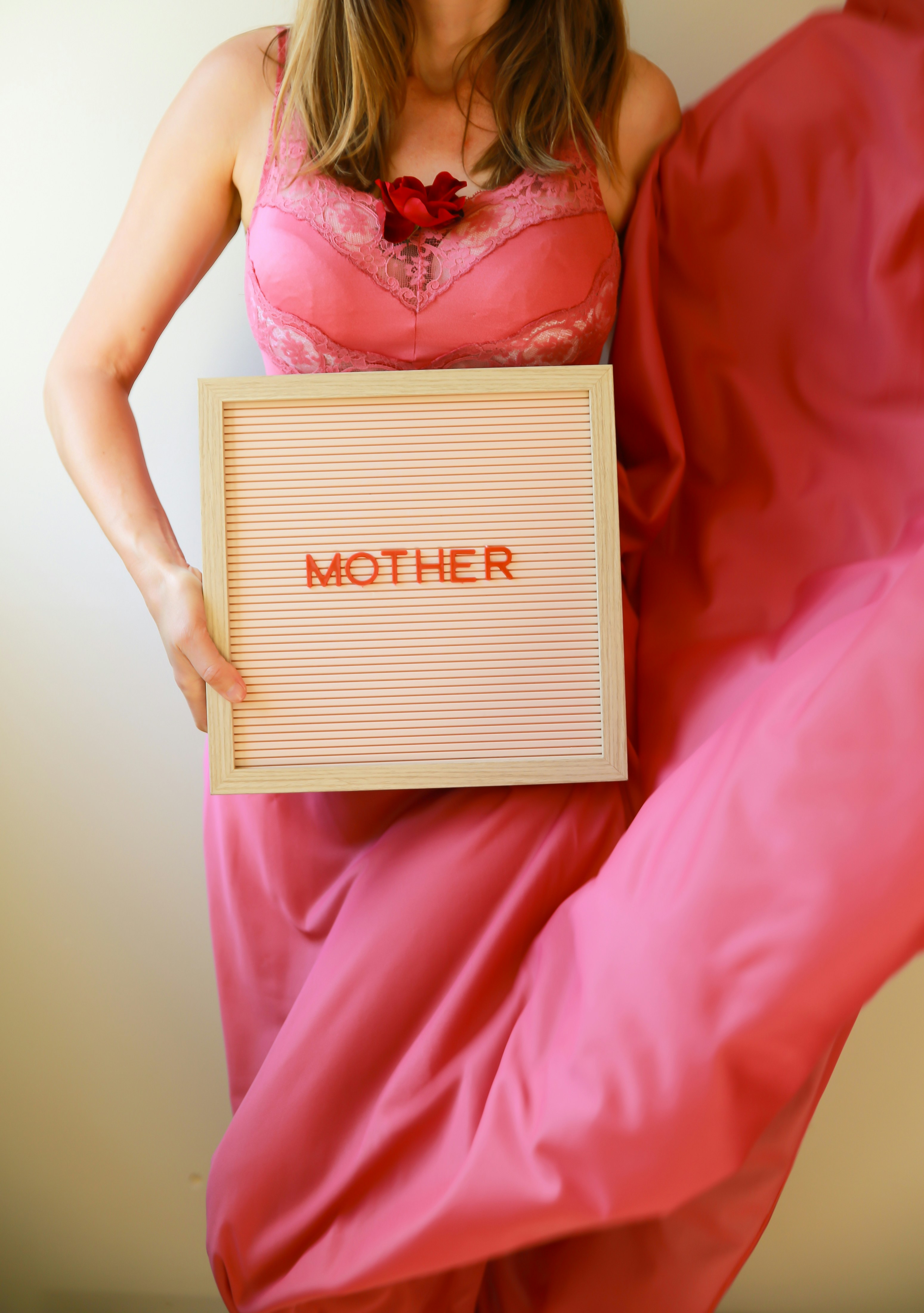 A woman holds a sign that reads "mother."