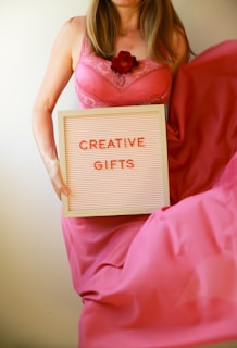 Woman holds a sign that says "creative gifts."