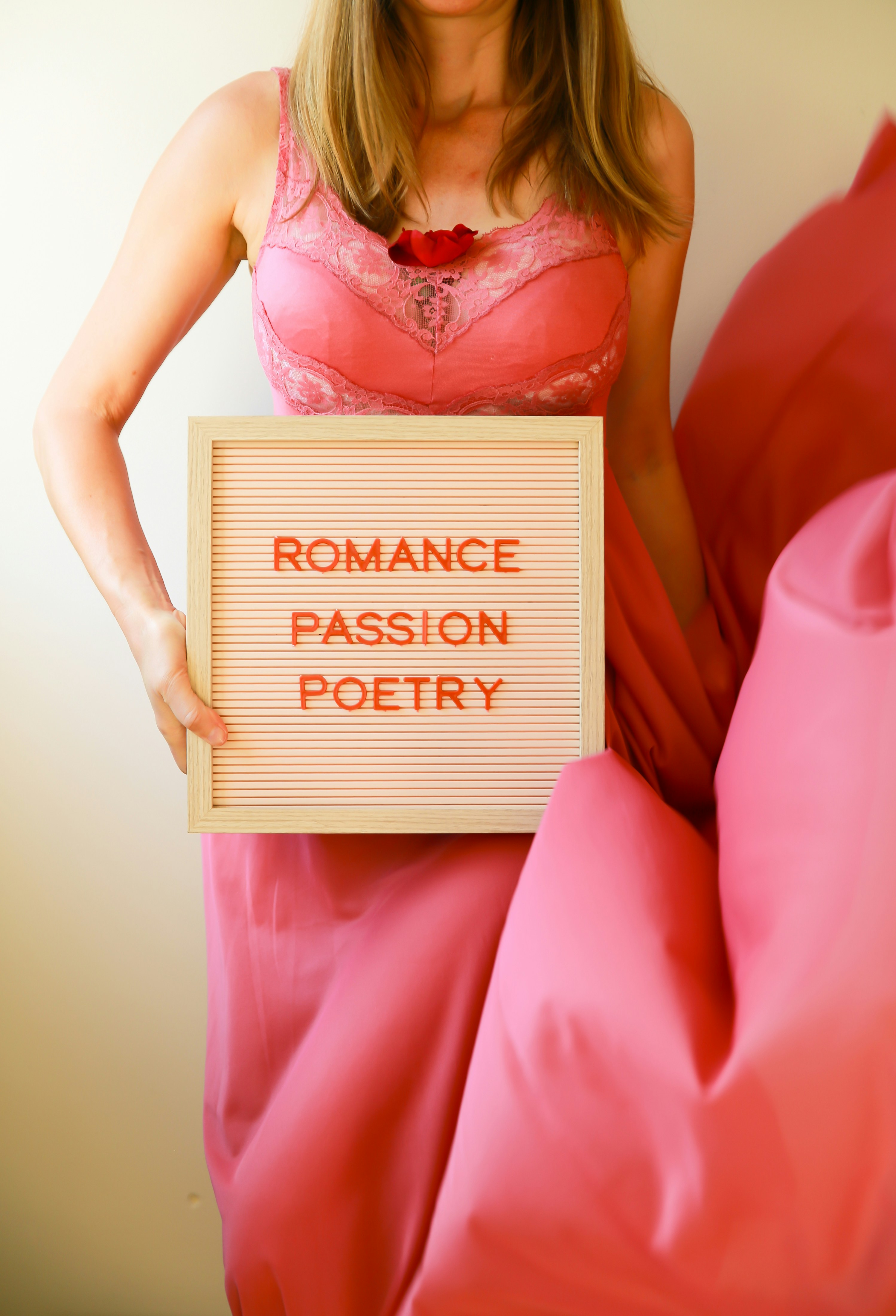 Woman holds a sign with words about romance.