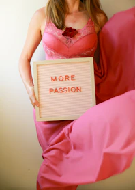 Woman holds a sign that says "more passion."