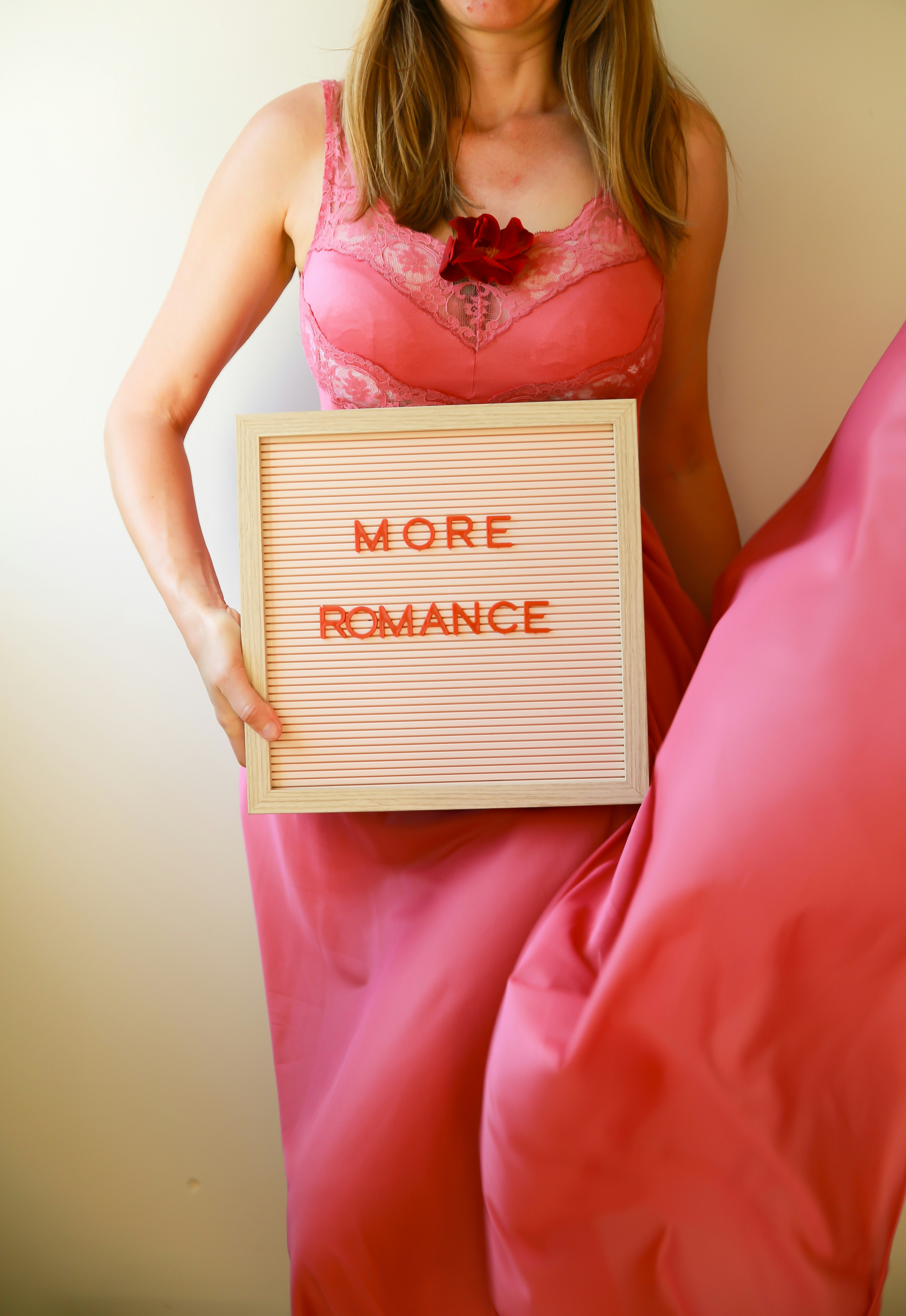 Woman holds a sign saying "more romance."